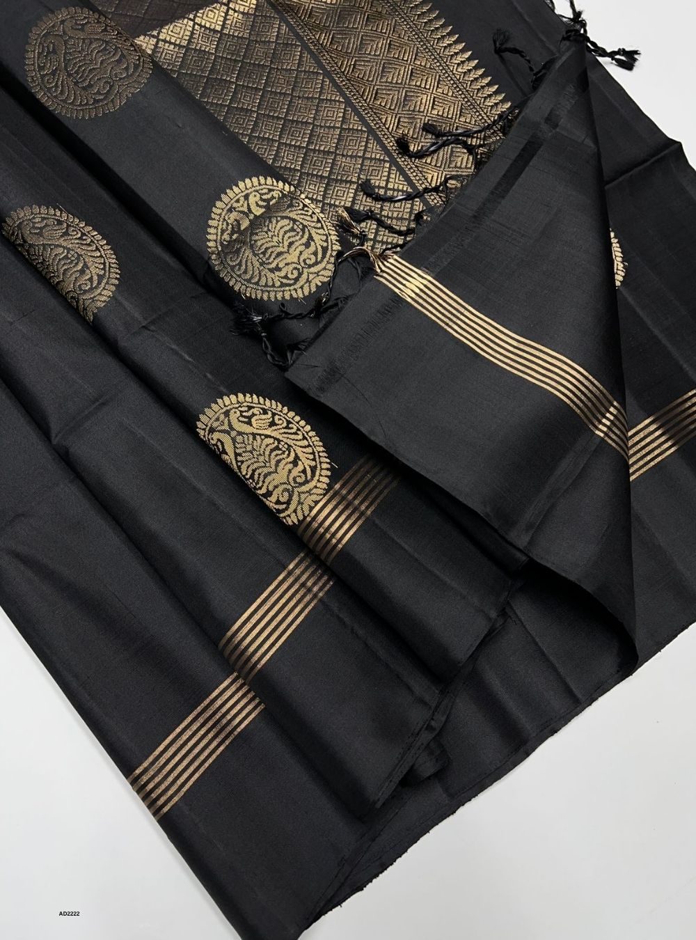 Black saree with gold embroidery on a white background