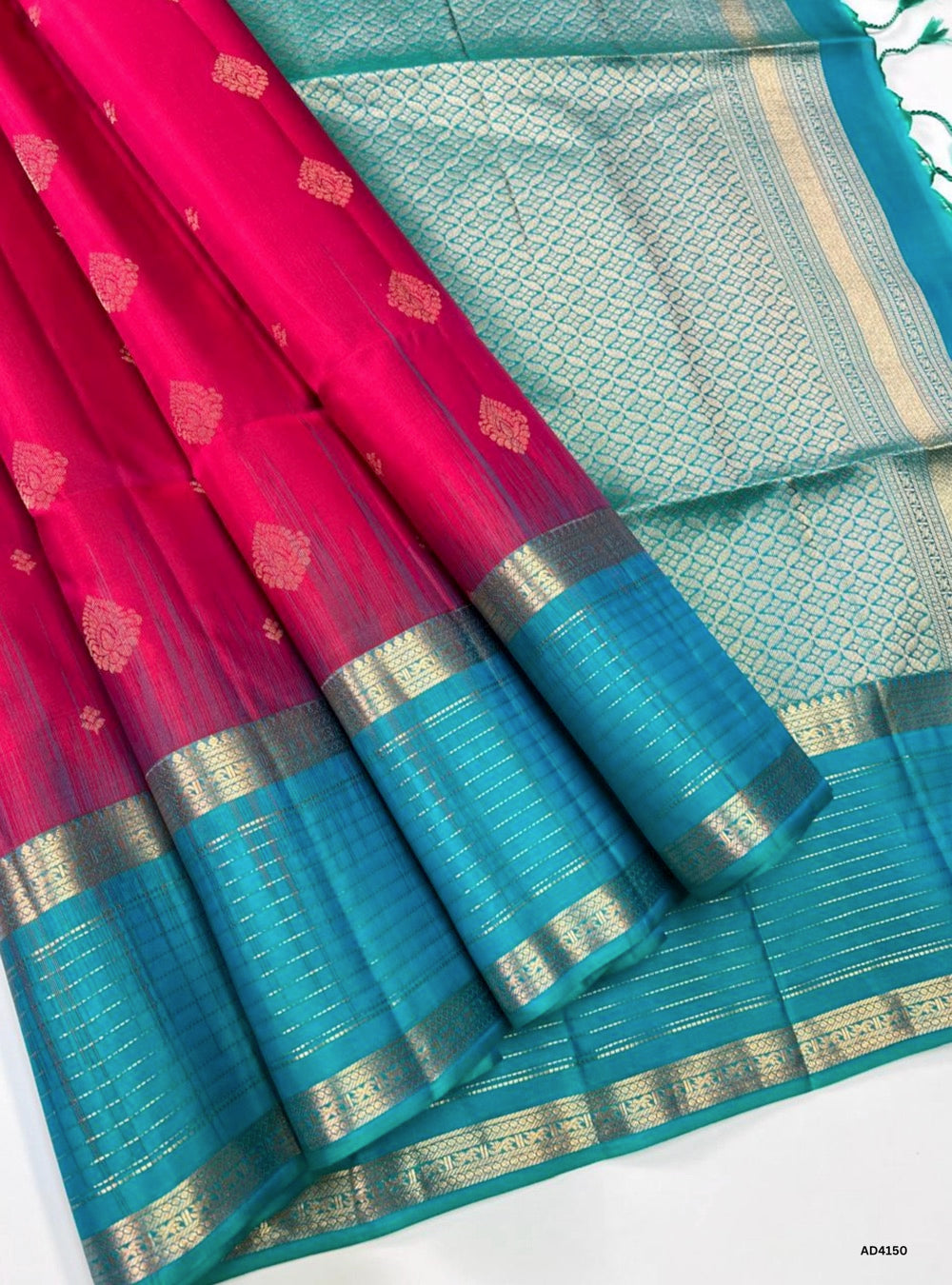 The Redish Pink & Mint Green Retta Pet Border Soft Silk Saree is a radiant handwoven creation that celebrates festive charm and cultural heritage. The redish pink shade conveys joy, auspiciousness, and feminine grace, while the mint green adds refreshing brightness and youthful vibrance. The Retta Pet temple‑inspired double line border enriches the saree with timeless grandeur, while pure gold zari detailing enhances its lustrous appeal. Perfect for weddings, temple ceremonies, and festive occasions, this s