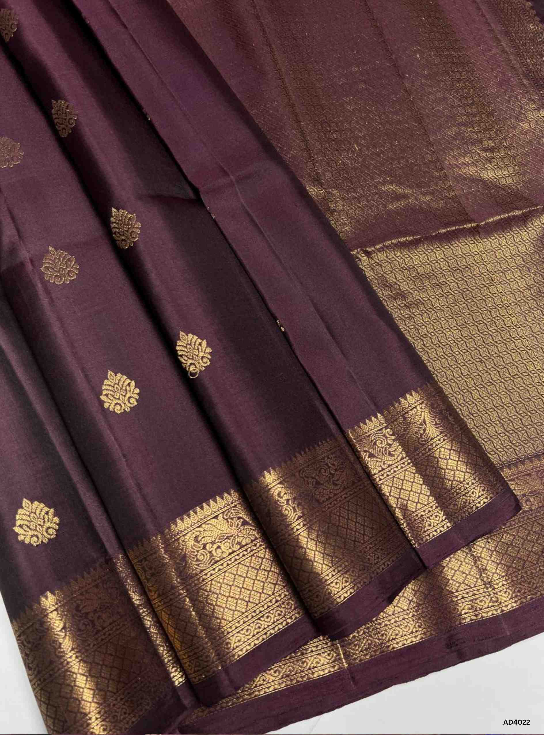 The Coffee Brown Kanchi Border Soft Silk Saree is a heritage handwoven creation that radiates timeless elegance. The deep coffee brown shade symbolizes grounded richness and cultural depth, while the grand Kanchi border, adorned with temple‑inspired motifs in pure gold zari, elevates its festive appeal. The shimmering pallu completes the ensemble, making it perfect for weddings, temple ceremonies, and cultural celebrations. This saree embodies South Indian craftsmanship with an earthy single‑tone palette en