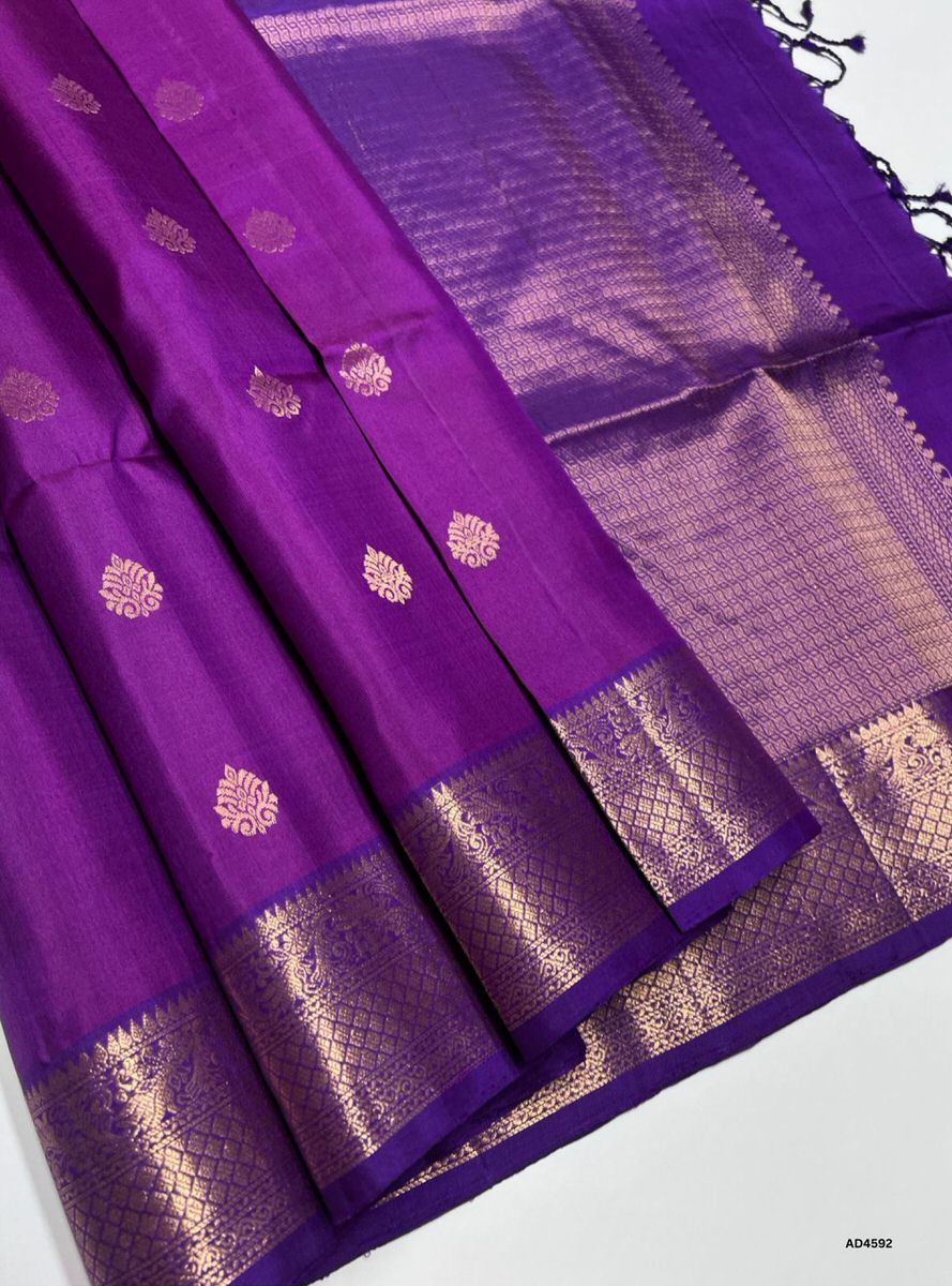 Purple saree with gold patterns on a white background