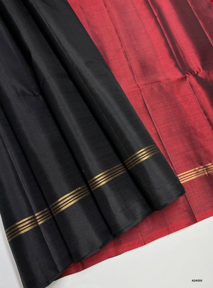 The Black & Maroon Plain Soft Silk Saree with Pure Gold Zari is a timeless handwoven creation that radiates regal charm and cultural elegance, making it ideal for weddings, temple ceremonies, and festive occasions.