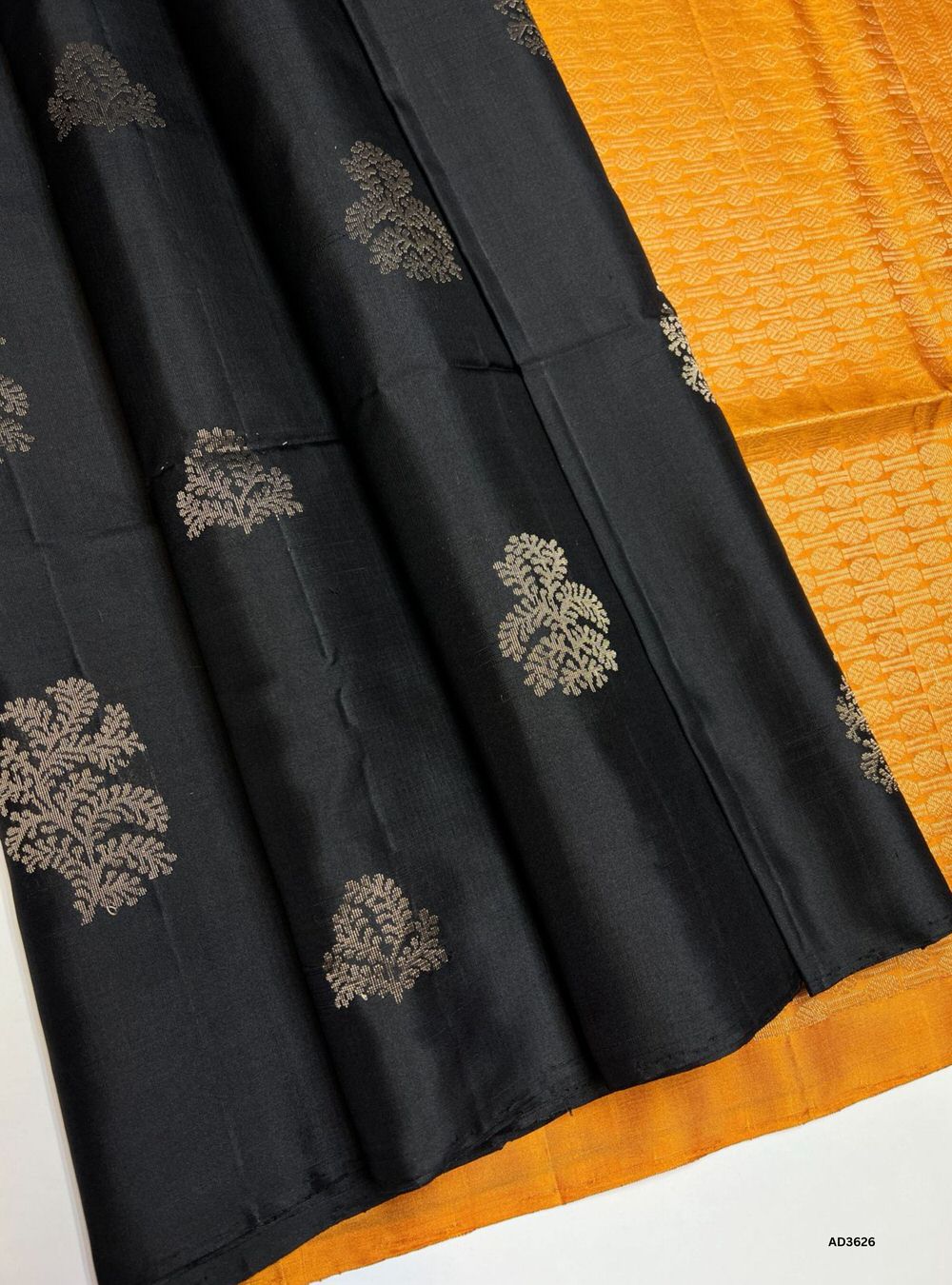 The Black & Mustard Soft Silk Saree is a striking handwoven creation featuring a bold black body enriched with shimmering zari. Its radiant mustard border and pallu highlight the intricate bhutta weave motifs, adding elegance and traditional charm. Perfect for weddings, festive occasions, and cultural gatherings, this saree blends timeless sophistication with luminous bhutta craftsmanship.