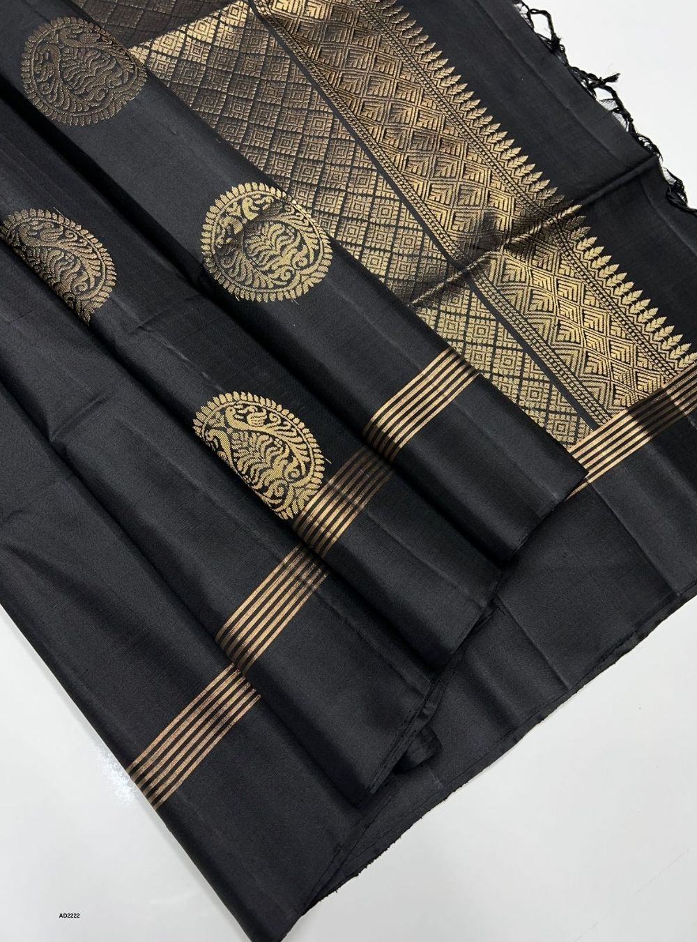 Black saree with gold embroidery on a white background