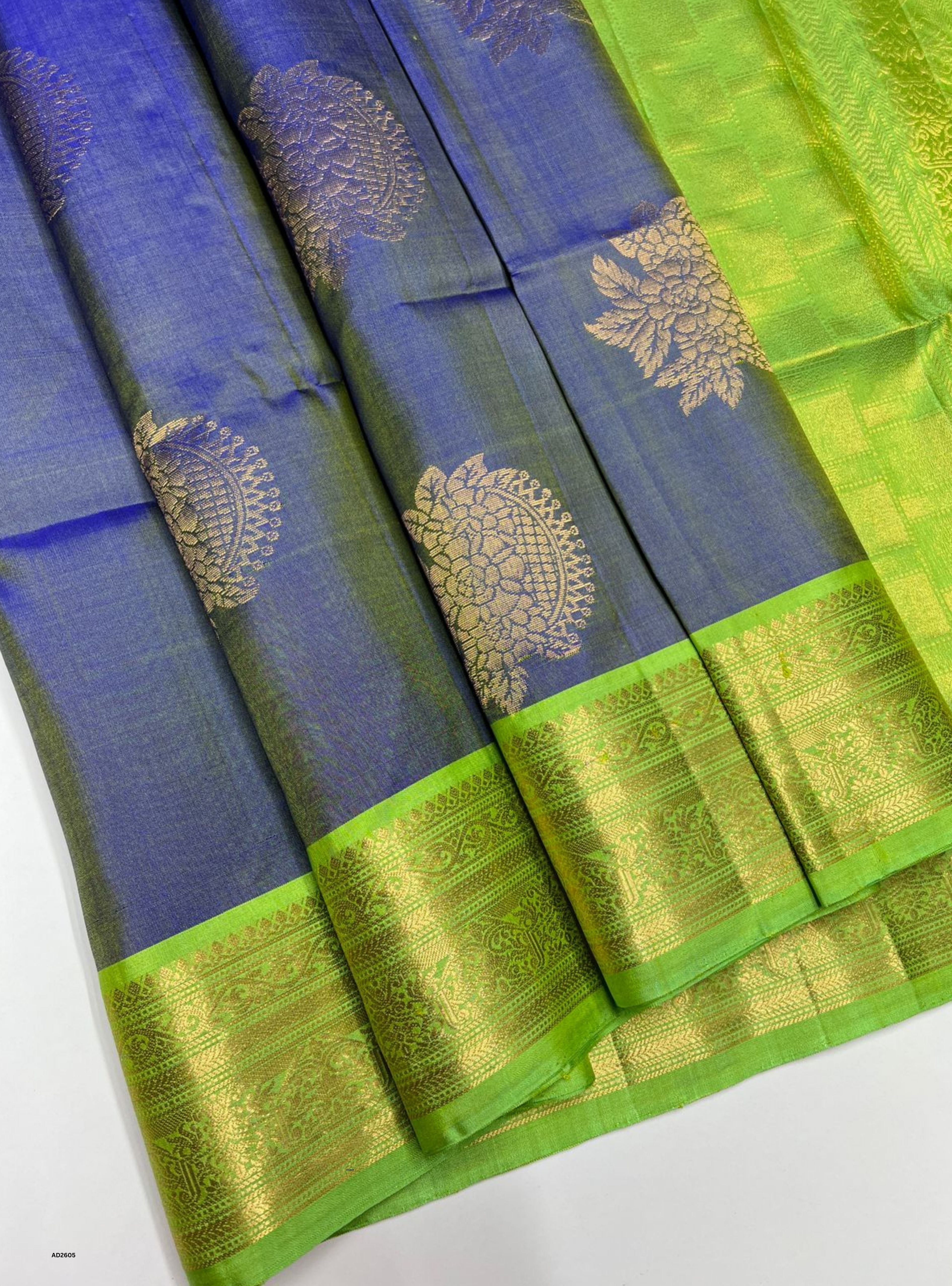 Blue and green saree with gold border on a white background