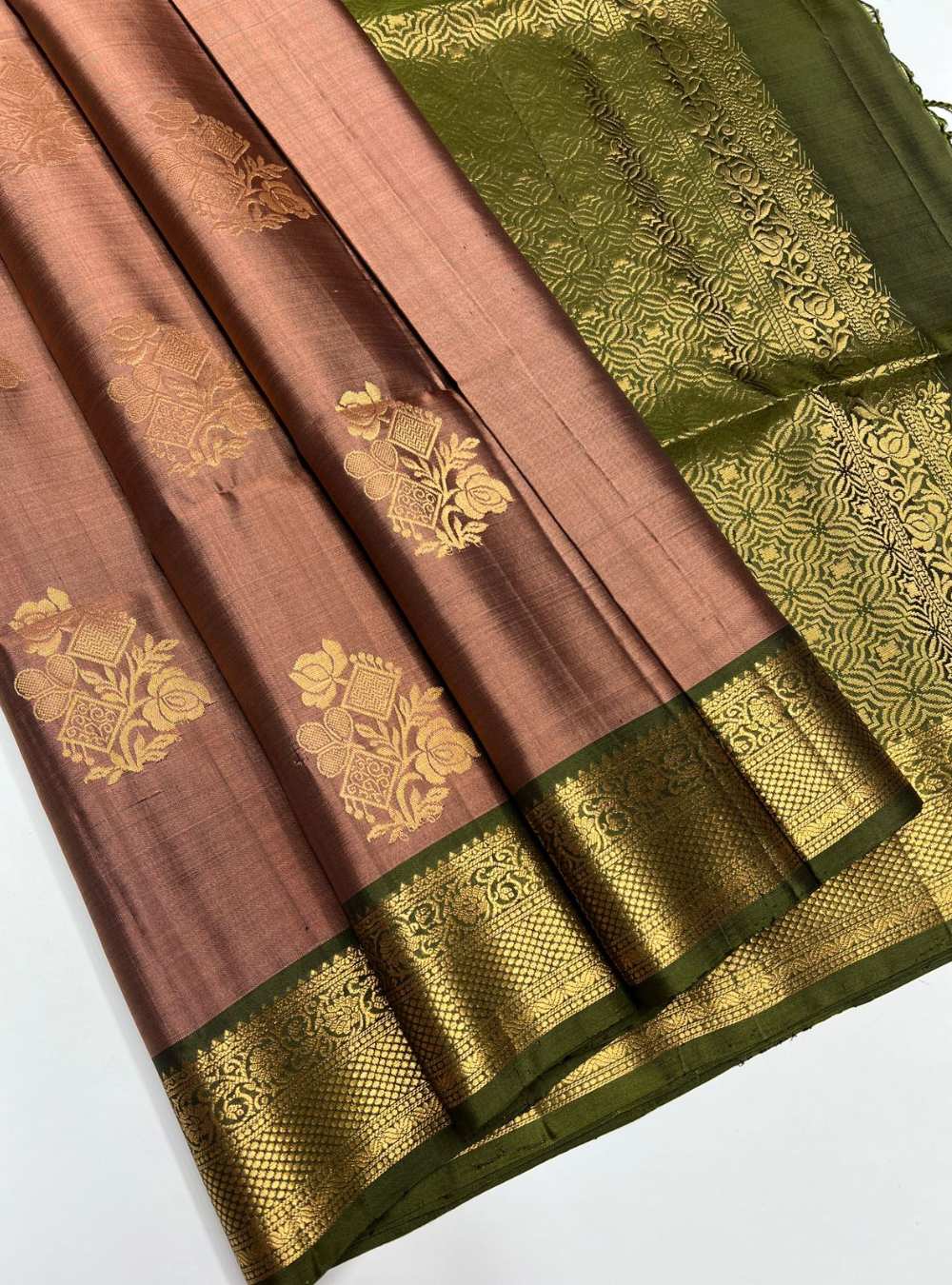 Brown and green saree with gold patterns on a white background