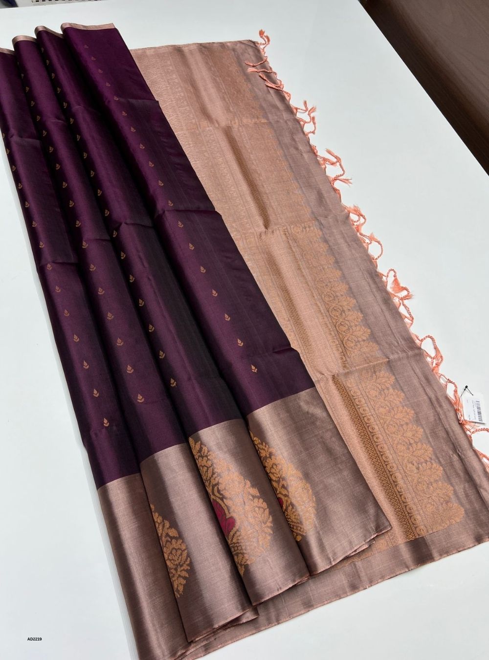 Brown and purple saree with decorative patterns on a white background