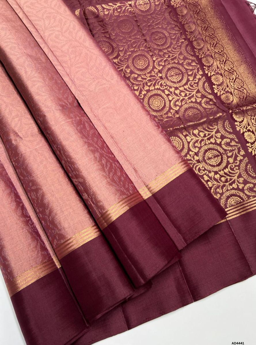The Cocoa & Coral Brown Soft Silk Bridal Saree with Half Fine Tested Gold Zari is a graceful handwoven creation that unites earthy richness with festive warmth, making it ideal for weddings, receptions, and temple ceremonies.