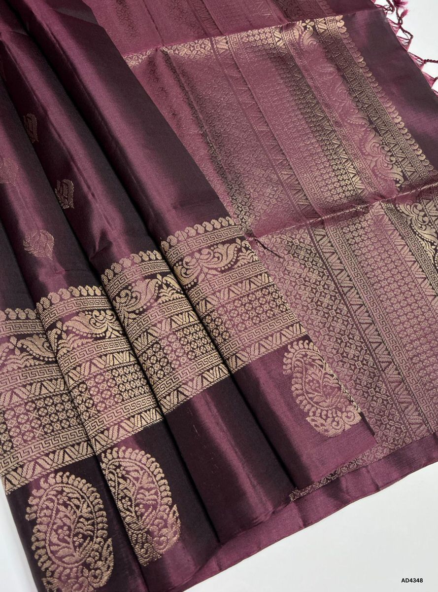 The Coffee Brown Fancy Border Soft Silk Saree is a refined handwoven creation that radiates cultural richness and festive charm. The coffee brown shade symbolizes warmth, devotion, and heritage depth, while the fancy border introduces a touch of ornamental artistry and modern sophistication. Enhanced with pure gold zari and a lustrous drape, this saree is perfect for weddings, temple ceremonies, and celebratory occasions. A timeless masterpiece, it blends earthy elegance with contemporary border weaving.