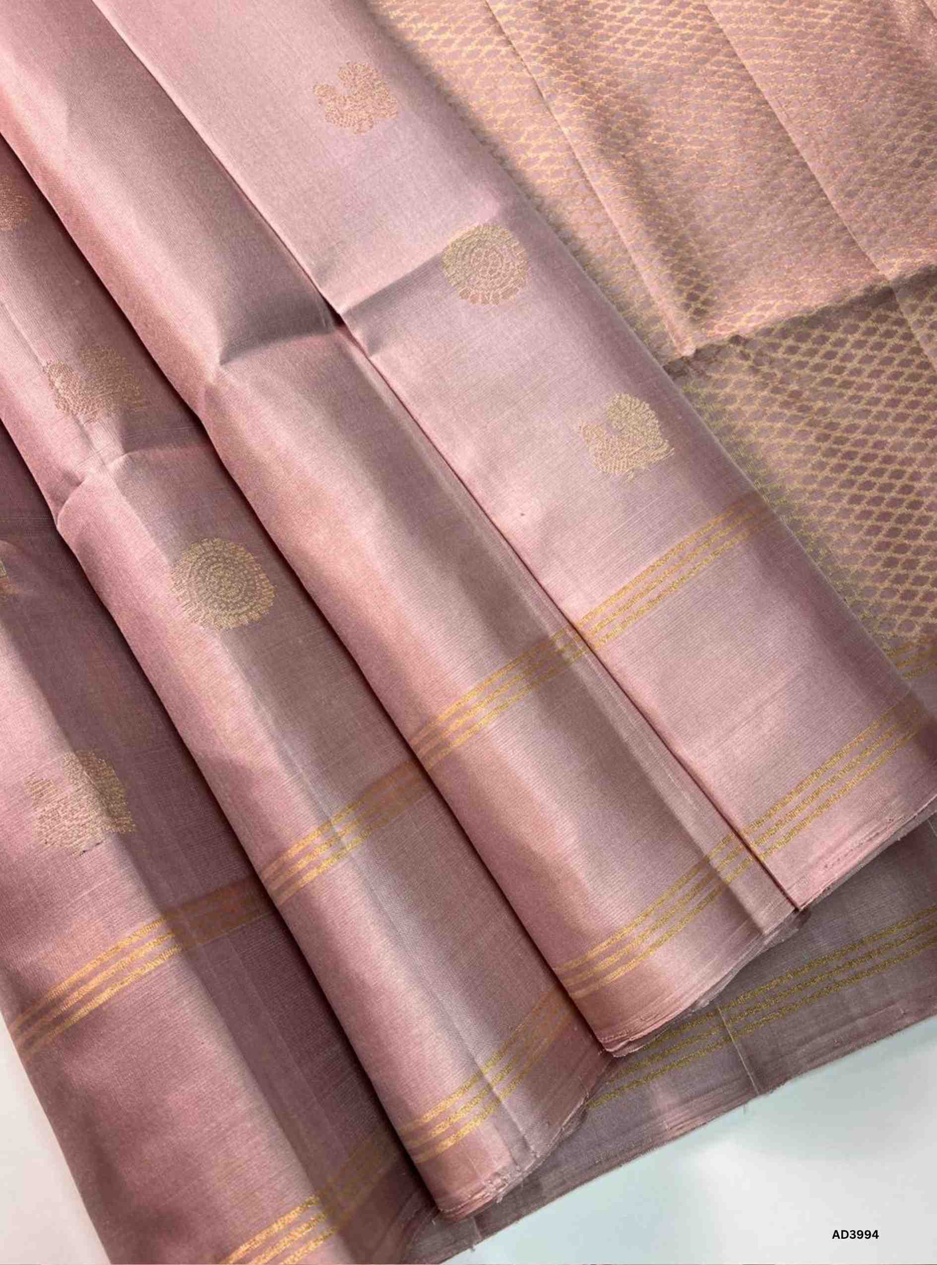 The Cream & Pink Bhutta Soft Silk Saree is a graceful handwoven creation that radiates festive charm with a refined dual‑tone palette. The soothing cream shade symbolizes purity and elegance, while the lively pink adds vibrancy and auspicious brilliance. The bhutta weave, adorned with intricate motifs, enhances the saree’s artistry, while zari highlights on the border and pallu lend a shimmering finish. Perfect for weddings, temple ceremonies, and cultural gatherings, this saree embodies South Indian crafts