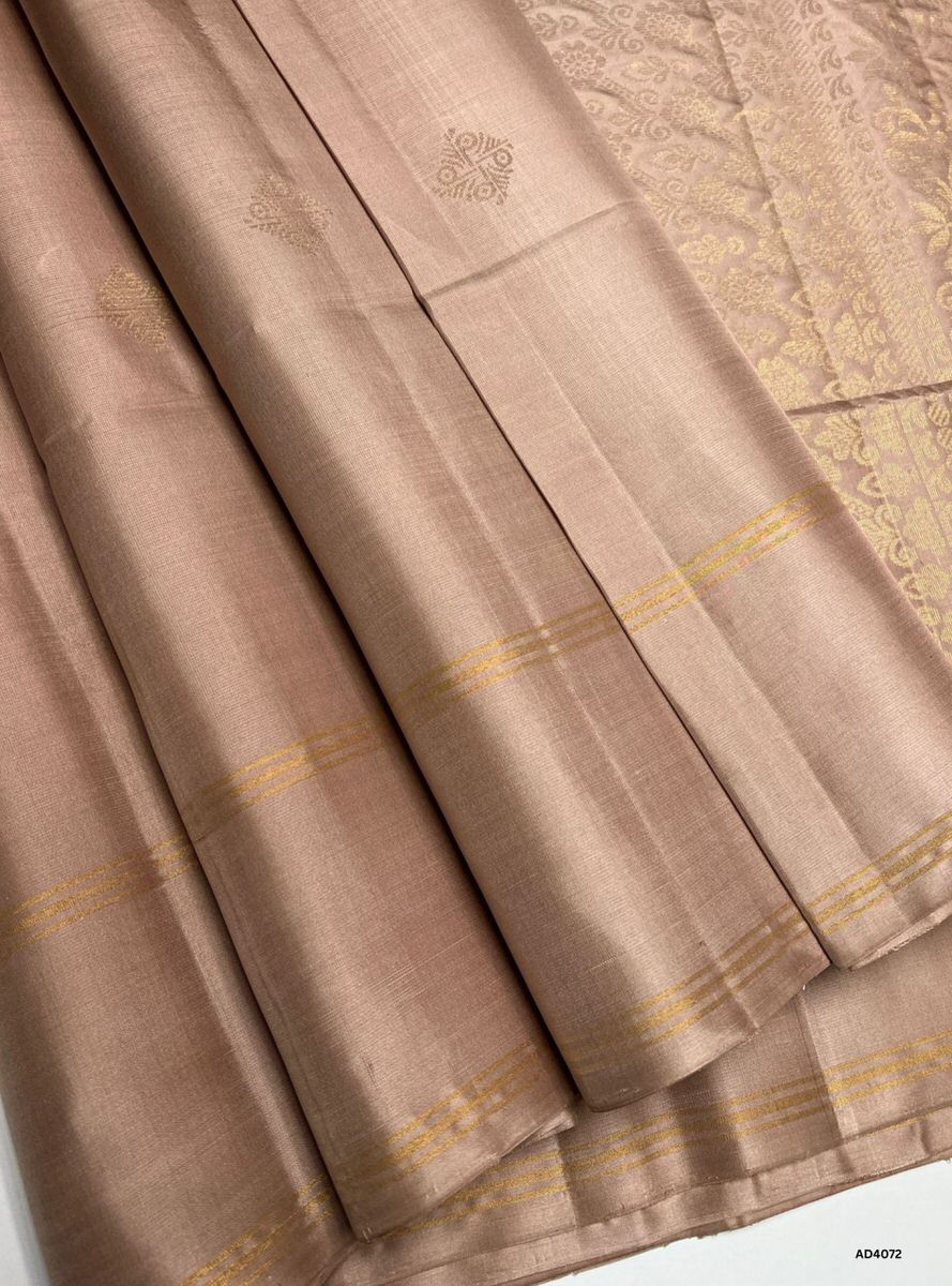 The Cream Soft Silk Bhutta Saree is a graceful handwoven creation that radiates purity, serenity, and timeless elegance. The soft cream shade symbolizes auspiciousness and refined charm, while the Bhutta motifs woven across the body add heritage depth and cultural richness. Enhanced with pure gold zari borders and a lustrous drape, this saree is ideal for weddings, temple ceremonies, and festive occasions. Its understated palette pairs beautifully with traditional jewelry, making it a versatile yet regal ad