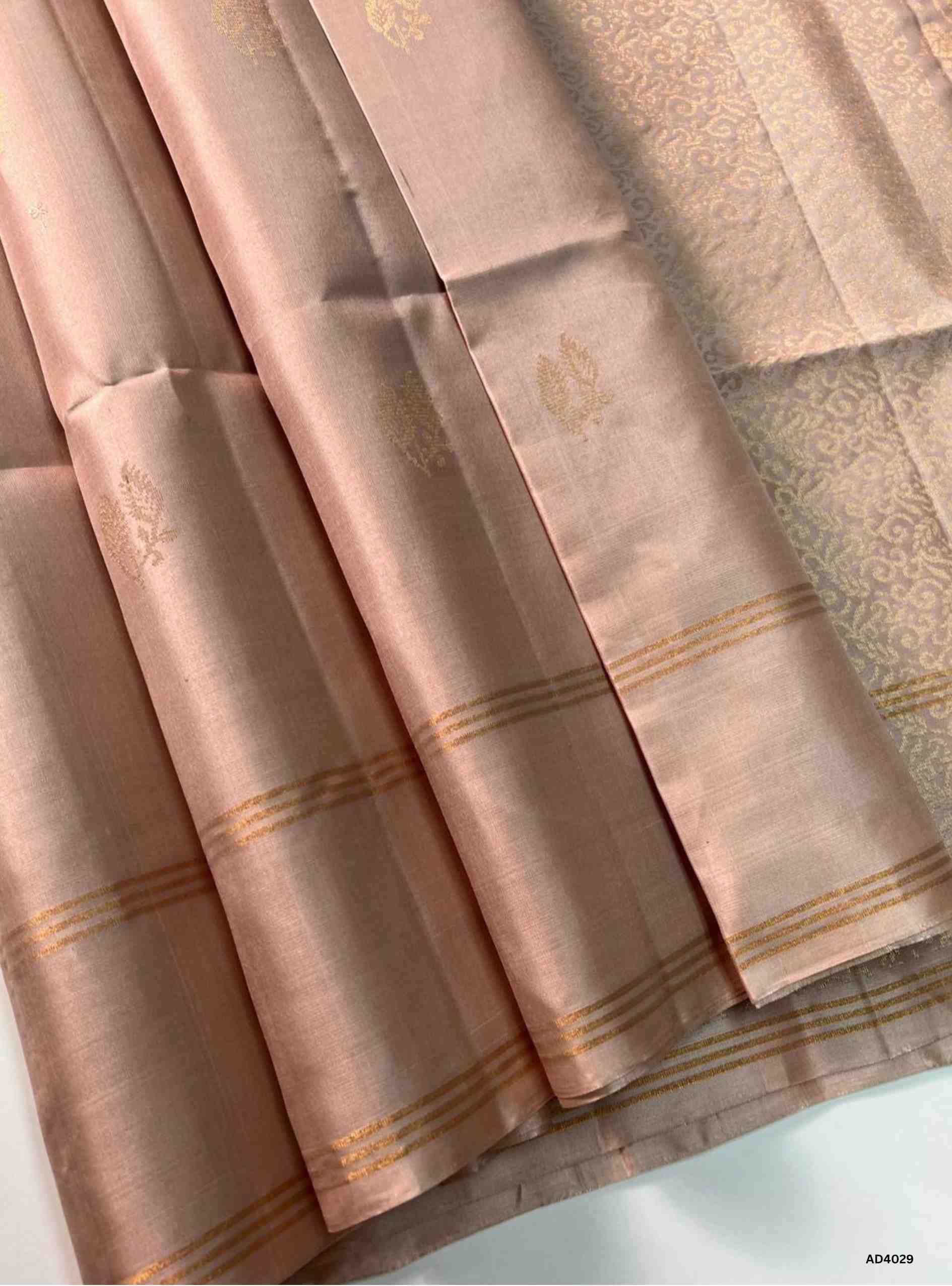 The Cream Bhutta Soft Silk Saree is a graceful handwoven creation that radiates understated charm and timeless elegance. The soothing cream shade symbolizes purity, serenity, and auspiciousness, making it a versatile choice for weddings, temple ceremonies, and cultural gatherings. The bhutta weave, adorned with delicate motifs, adds texture and artistry, while zari highlights on the border and pallu lend a shimmering finish. A refined pastel‑tone ensemble that beautifully reflects South Indian weaving herit