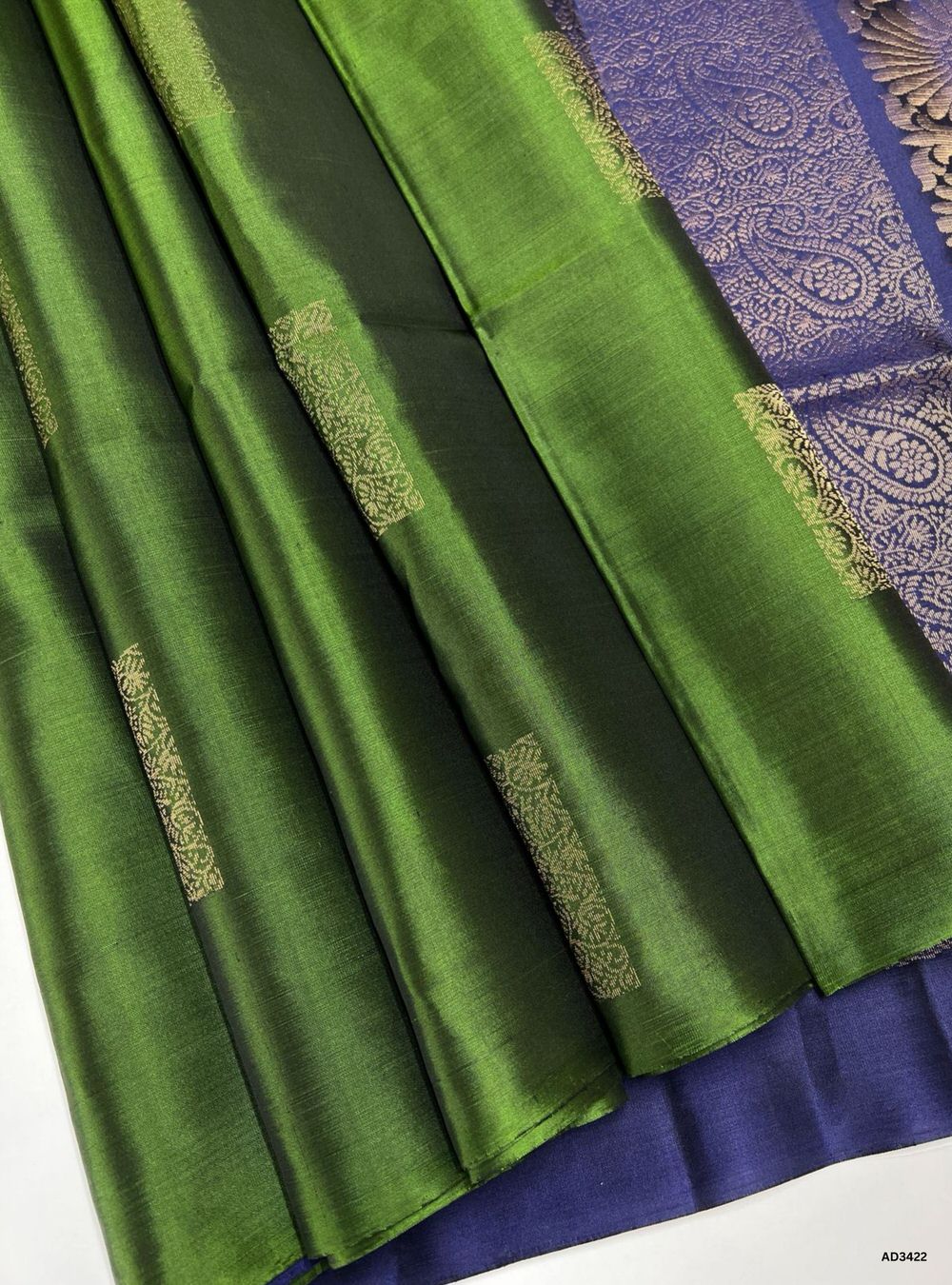 The Dark Green & Dark Navy Soft Silk Saree is a regal handwoven creation featuring a deep green body adorned with traditional Bhutta motifs. The rich navy border and pallu add grandeur and contrast, while zari highlights shimmer across the motifs. Perfect for weddings, festive occasions, and cultural gatherings, this saree blends earthy elegance with timeless Bhutta craftsmanship.