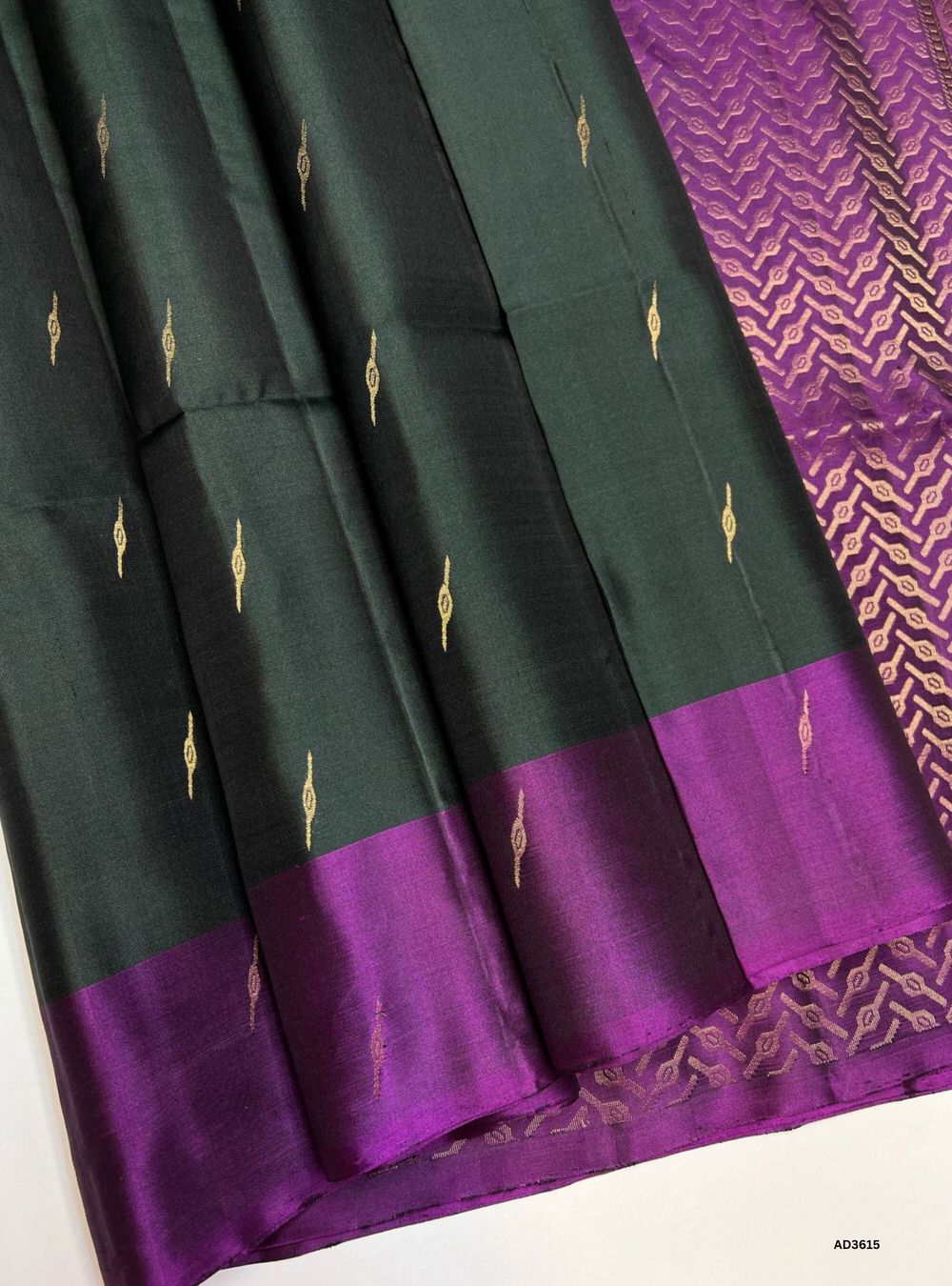 The Dark Green & Purple Soft Silk Saree is a majestic handwoven creation featuring a rich dark green body enriched with shimmering zari. Its regal purple border and pallu highlight the intricate bhutta weave motifs, adding elegance and traditional charm. Perfect for weddings, festive occasions, and cultural gatherings, this saree blends earthy depth with timeless bhutta craftsmanship.