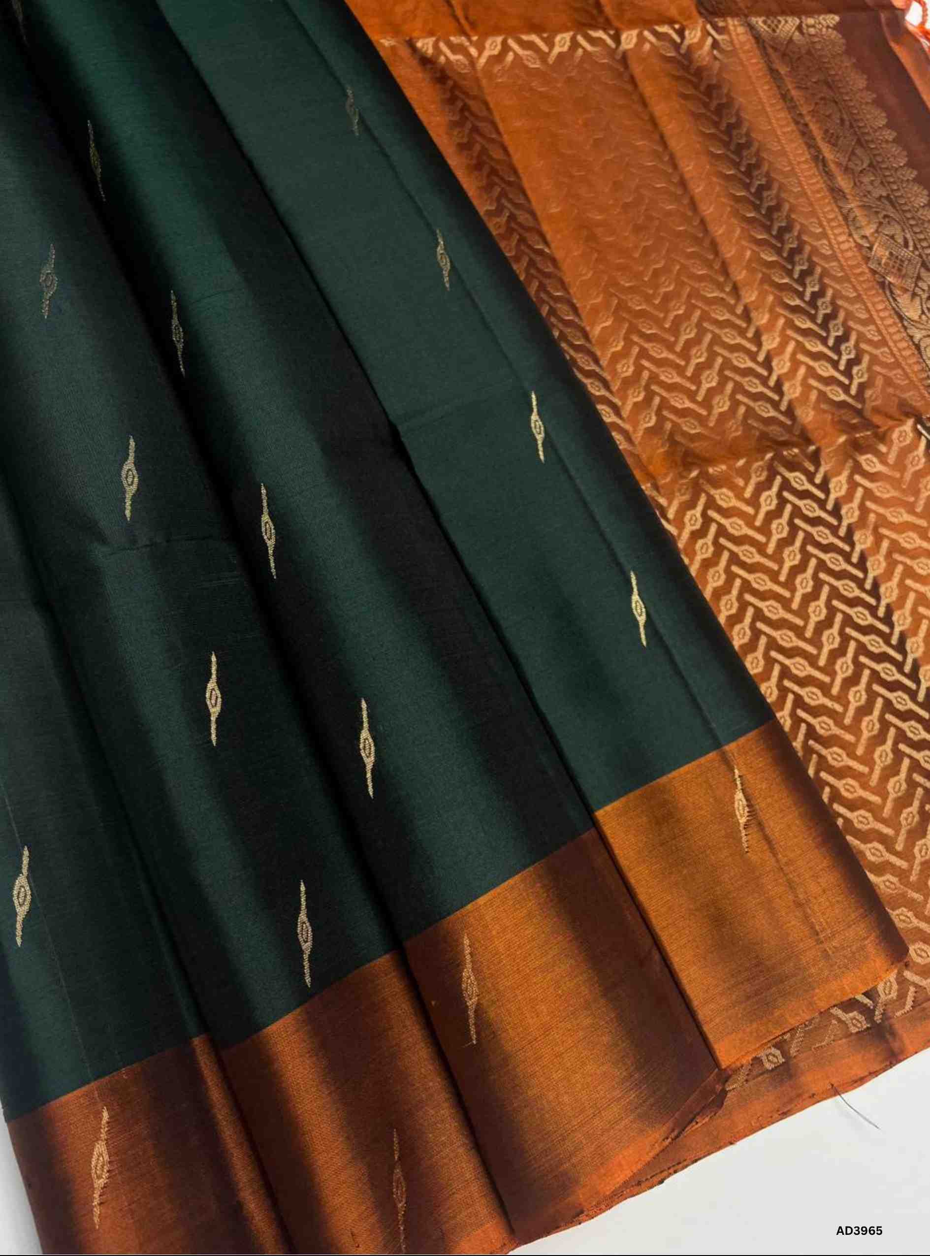The Dark Green & Rust Orange Bhutta Soft Silk Saree is a striking handwoven creation that celebrates festive grandeur in earthy dual tones. The deep dark green shade radiates prosperity and cultural depth, while the rust orange adds warmth and celebratory brilliance. The bhutta weave, adorned with delicate motifs, enhances the saree’s artistry, while zari highlights on the border and pallu lend a shimmering appeal. Perfect for weddings, temple ceremonies, and cultural gatherings, this saree embodies South I
