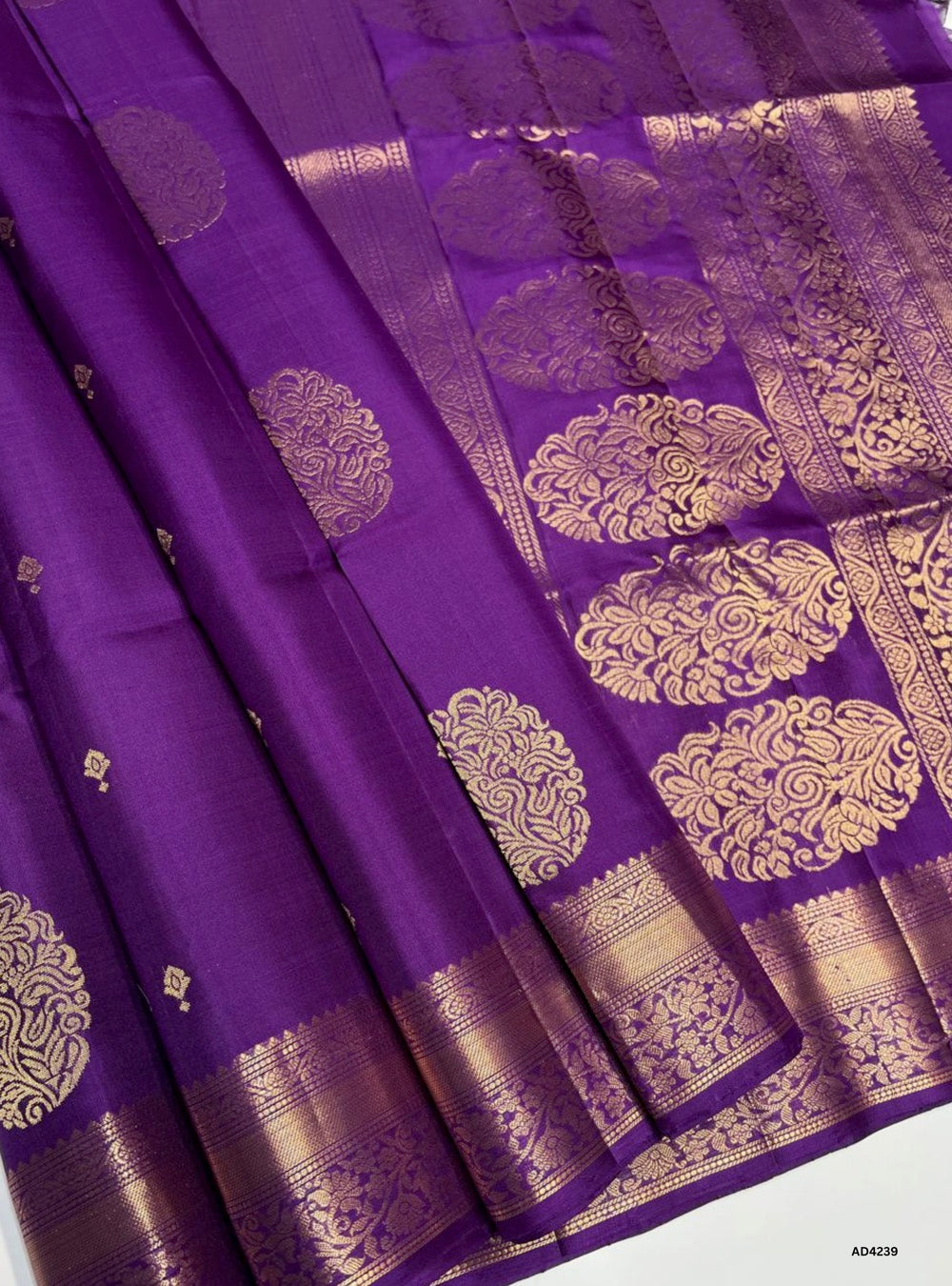 The Dark Purple Kanchi Border Soft Silk Saree is a majestic handwoven creation that radiates regal elegance and cultural richness. The dark purple shade symbolizes royalty, devotion, and spiritual depth, while the traditional Kanchi border enriched with pure gold zari elevates its heritage appeal. With its lustrous drape and coordinated blouse, this saree is perfect for weddings, temple ceremonies, and festive occasions. A timeless piece of artistry, it blends jewel‑tone vibrance with the grandeur of Kanchi
