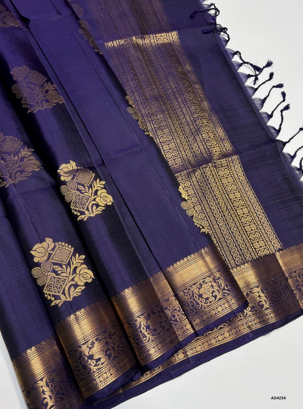 The Deep Purple Kanchi Border Soft Silk Saree is a majestic handwoven creation that radiates regal elegance and cultural richness. The deep purple shade symbolizes royalty, devotion, and spiritual depth, while the traditional Kanchi border enriched with pure gold zari elevates its heritage appeal. With its lustrous drape and coordinated blouse, this saree is perfect for weddings, temple ceremonies, and festive occasions. A timeless piece of artistry, it blends jewel‑tone vibrance with the grandeur of Kanchi