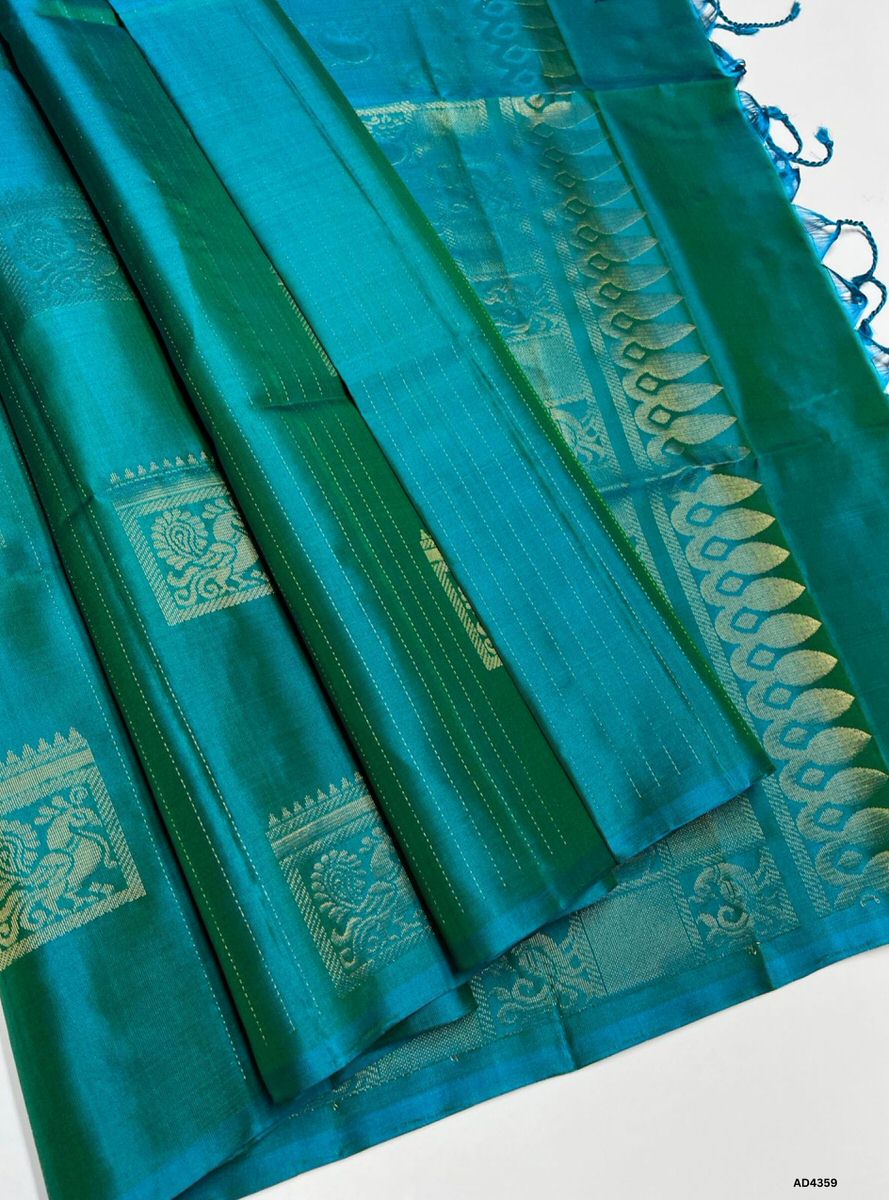 The Dual Tone Green Bhutta Soft Silk Saree is a radiant handwoven creation that celebrates festive charm and cultural grandeur. The dual tone green shade symbolizes prosperity, devotion, and vibrance, while the bhutta motifs scattered across the body enrich the saree with ornamental artistry. Enhanced with pure gold zari borders and a lustrous drape, this saree is perfect for weddings, temple ceremonies, and celebratory occasions. A timeless masterpiece, it blends auspicious green brilliance with motif‑cent