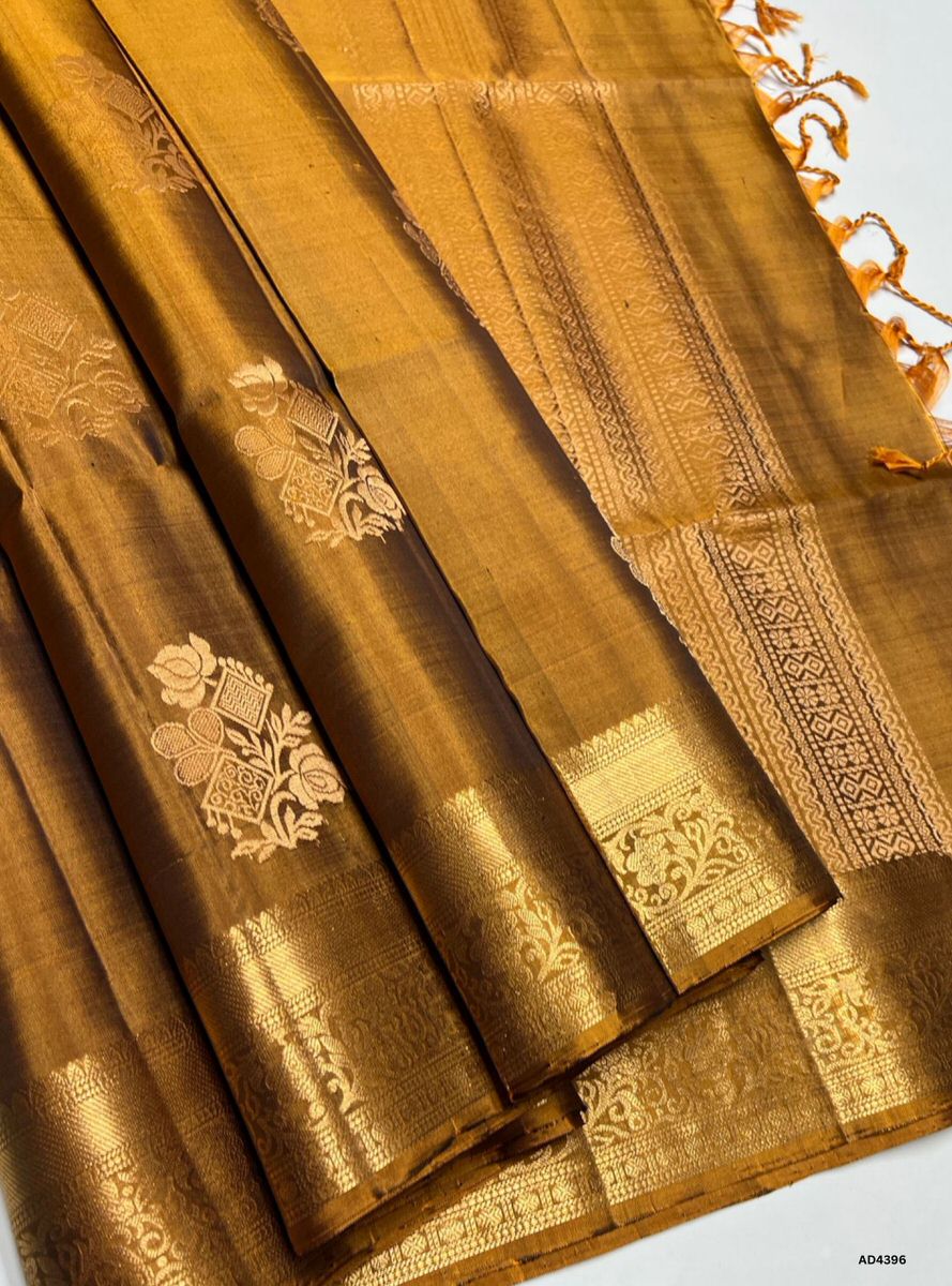 The Fenugreek Kanchi Border Soft Silk Saree is a distinctive handwoven creation that radiates earthy elegance and cultural depth. The fenugreek green shade, inspired by nature’s herbal richness, conveys prosperity, freshness, and grounded charm. Paired with a traditional Kanchipuram temple‑inspired zari border and a lustrous drape, this saree is ideal for weddings, temple ceremonies, and festive occasions. Its unique tone and heritage motifs reflect the artistry of South Indian weaving, offering a refined b