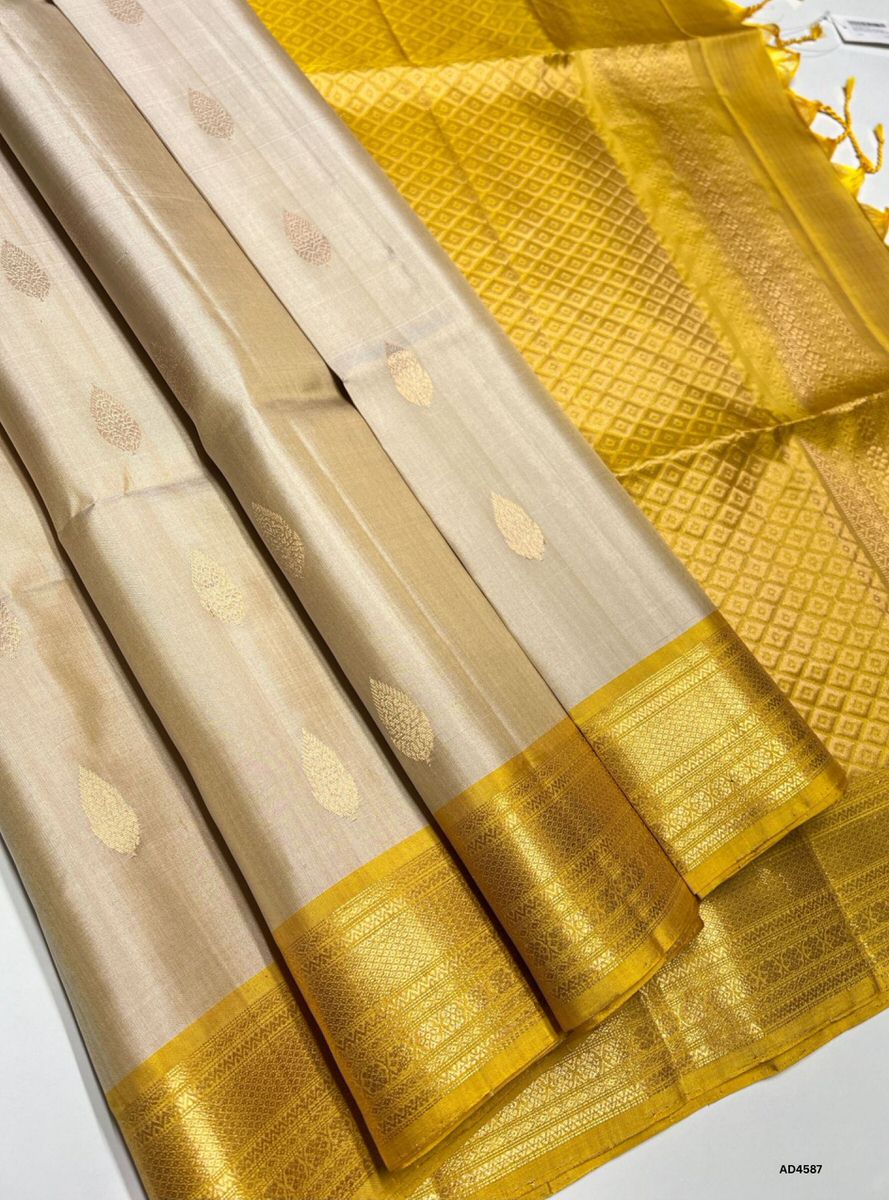 The Ivory & Yellow Kanchi Border Soft Silk Saree with Pure Gold Zari is a graceful handwoven creation that unites pastel calmness with festive vibrance, making it ideal for weddings, temple ceremonies, and cultural occasions.