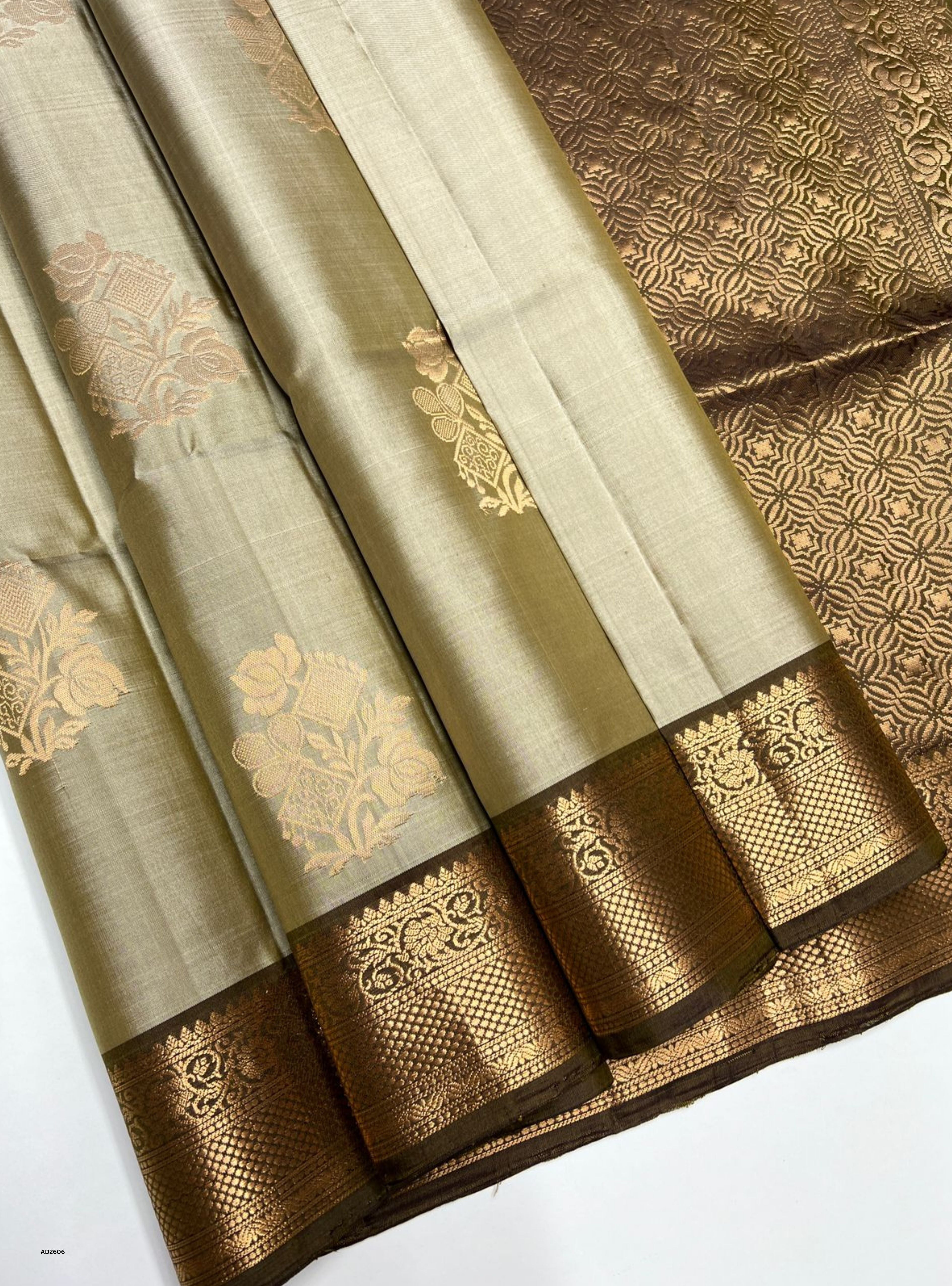 Two sarees with gold and brown patterns on a white background