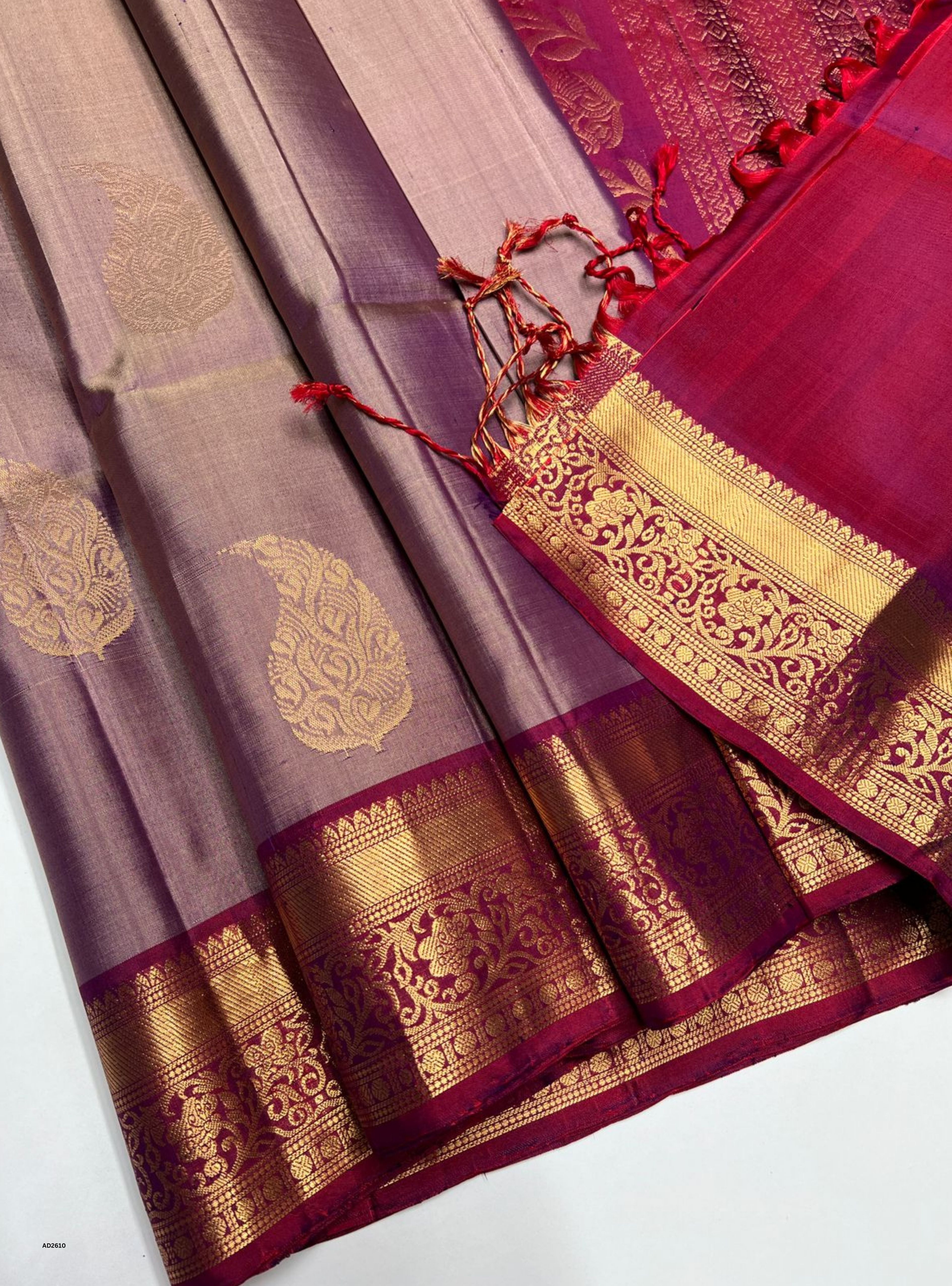 Saree with gold and red patterns on a white background