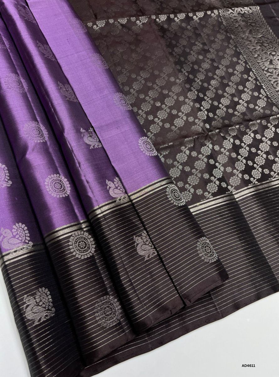 The Lilac & Coffee Brown Soft Silk Saree with Pure Gold Zari is a graceful handwoven creation that unites pastel charm with earthy richness, making it perfect for weddings, festive occasions, and temple ceremonies.