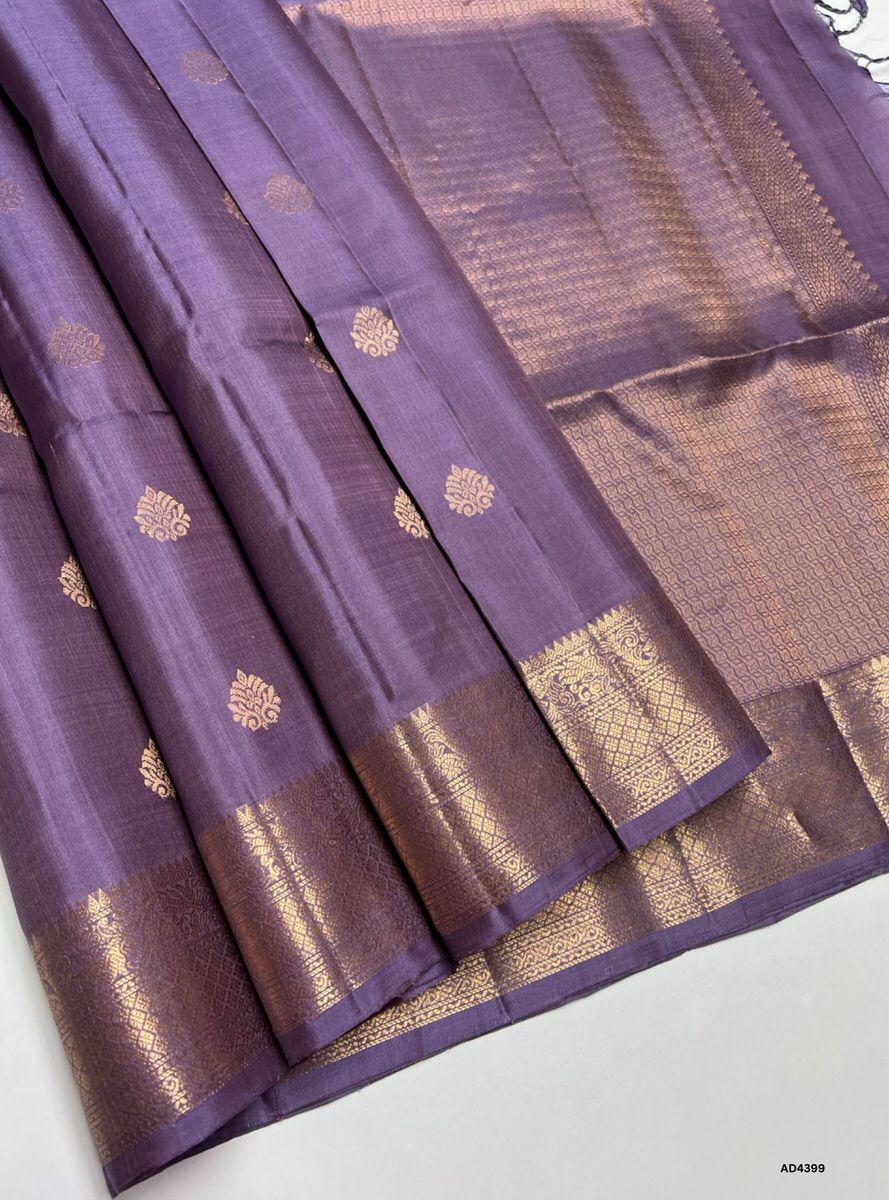 The Lilac Kanchi Border Soft Silk Saree is a graceful handwoven creation that radiates serene elegance and cultural richness. The lilac shade conveys calmness, refinement, and modern sophistication, while the traditional Kanchi border enriched with pure gold zari elevates its heritage appeal. With its lustrous drape and coordinated blouse, this saree is perfect for weddings, temple ceremonies, and festive occasions. A timeless piece of artistry, it blends pastel serenity with the grandeur of Kanchipuram wea