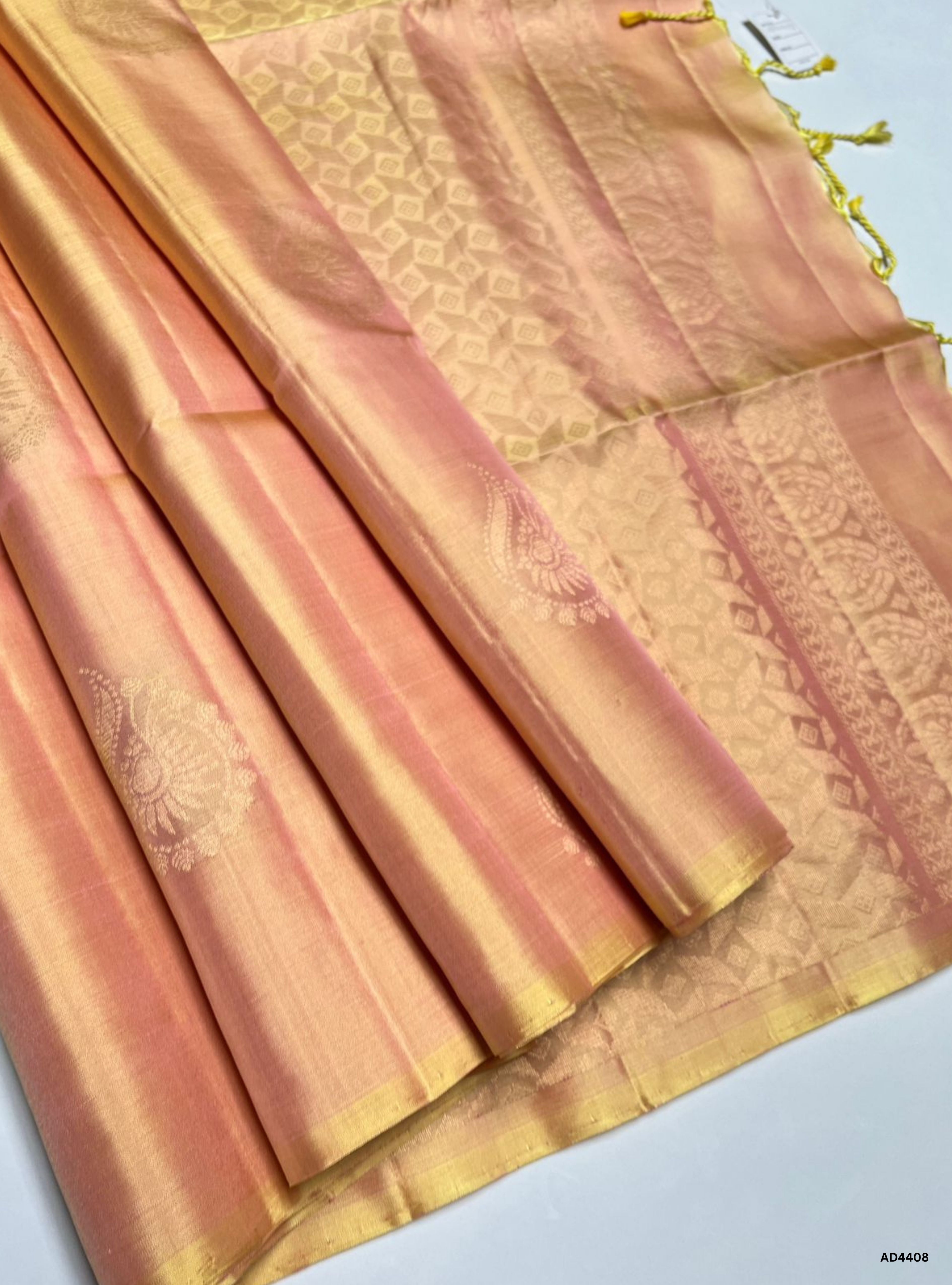 The Macaroon Soft Silk Saree with Half Fine Tested Gold Zari and bhutta motifs is a graceful handwoven creation that combines pastel warmth with festive artistry, making it ideal for weddings, temple ceremonies, and cultural celebrations.