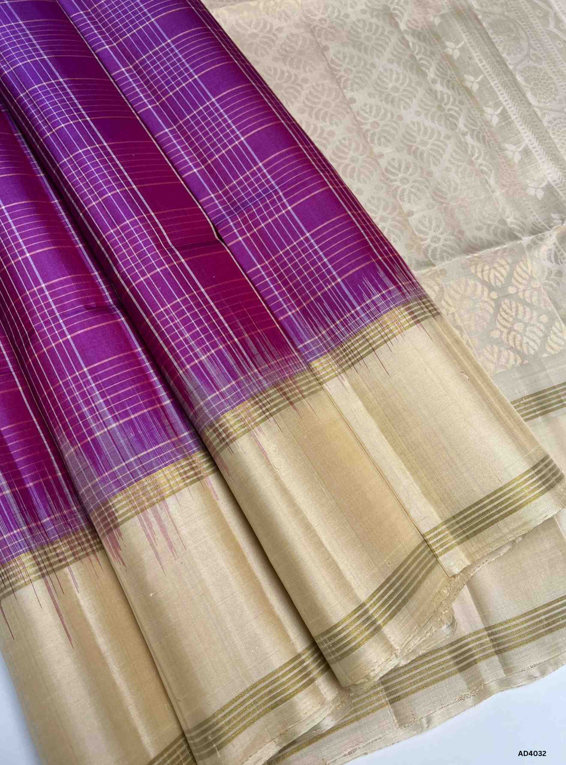 The Magenta & Crème Checkered Soft Silk Saree is a radiant handwoven creation that balances festive brilliance with subtle elegance. The vibrant magenta shade symbolizes joy, prosperity, and auspiciousness, while the soft crème tone adds sophistication, serenity, and timeless charm. The checkered weave enhances its geometric appeal, while the Retta Pet border, a hallmark of Kanchipuram artistry, features temple‑inspired double lines in pure gold zari. Perfect for weddings, temple ceremonies, and festive occ