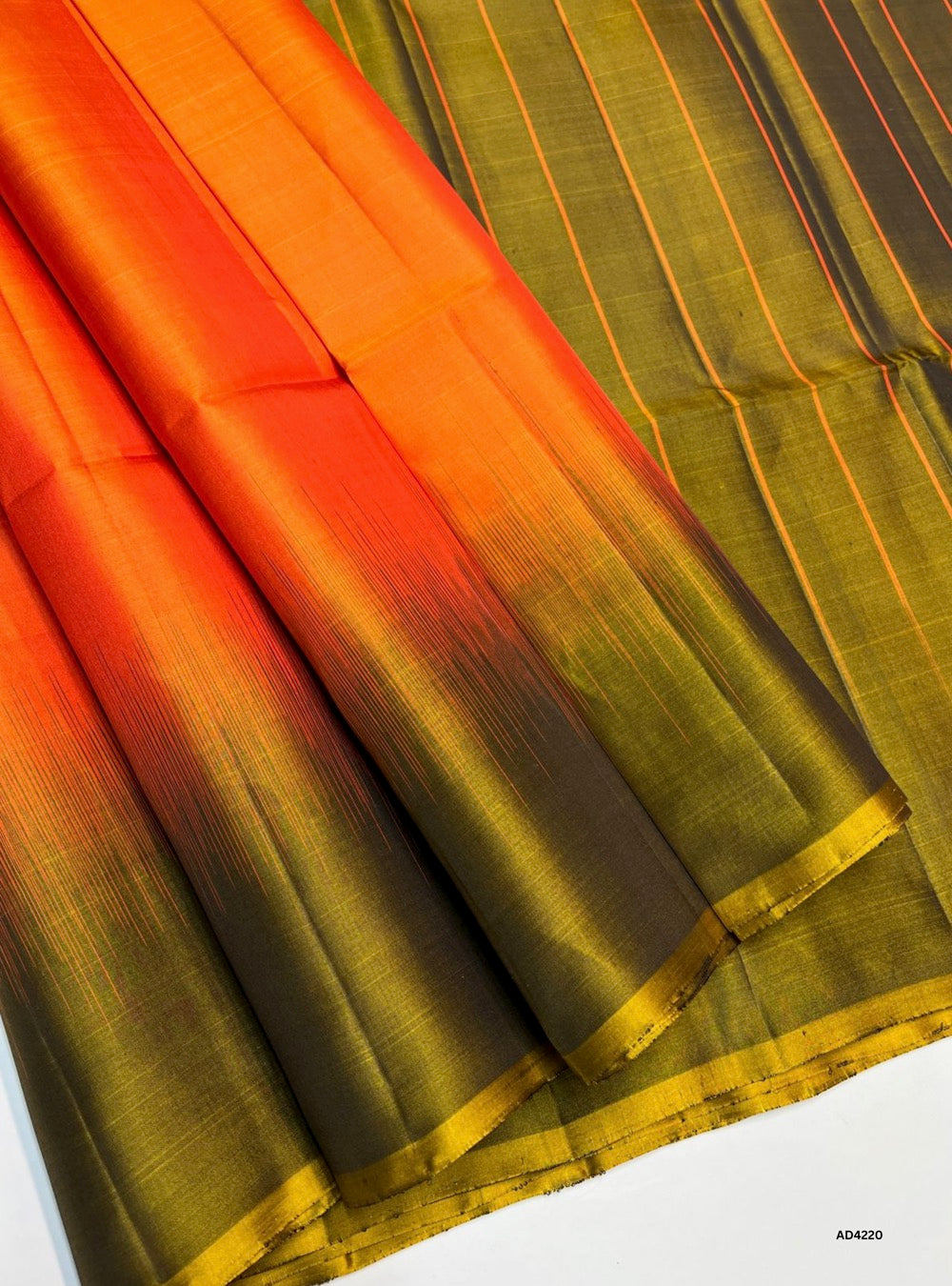 The Orange & Olive Green Plain Soft Silk Saree is a striking handwoven creation that radiates festive charm and cultural elegance. The vibrant orange shade symbolizes joy, energy, and celebration, while the olive green adds earthy sophistication and balance. With its plain weave enriched by zari highlights, this saree offers a refined blend of simplicity and grandeur. Perfect for weddings, temple ceremonies, and cultural gatherings, it reflects South Indian craftsmanship with a dual‑tone palette that is bot