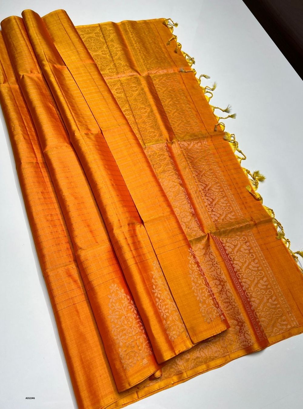 Orange fabric with gold patterns on a white background