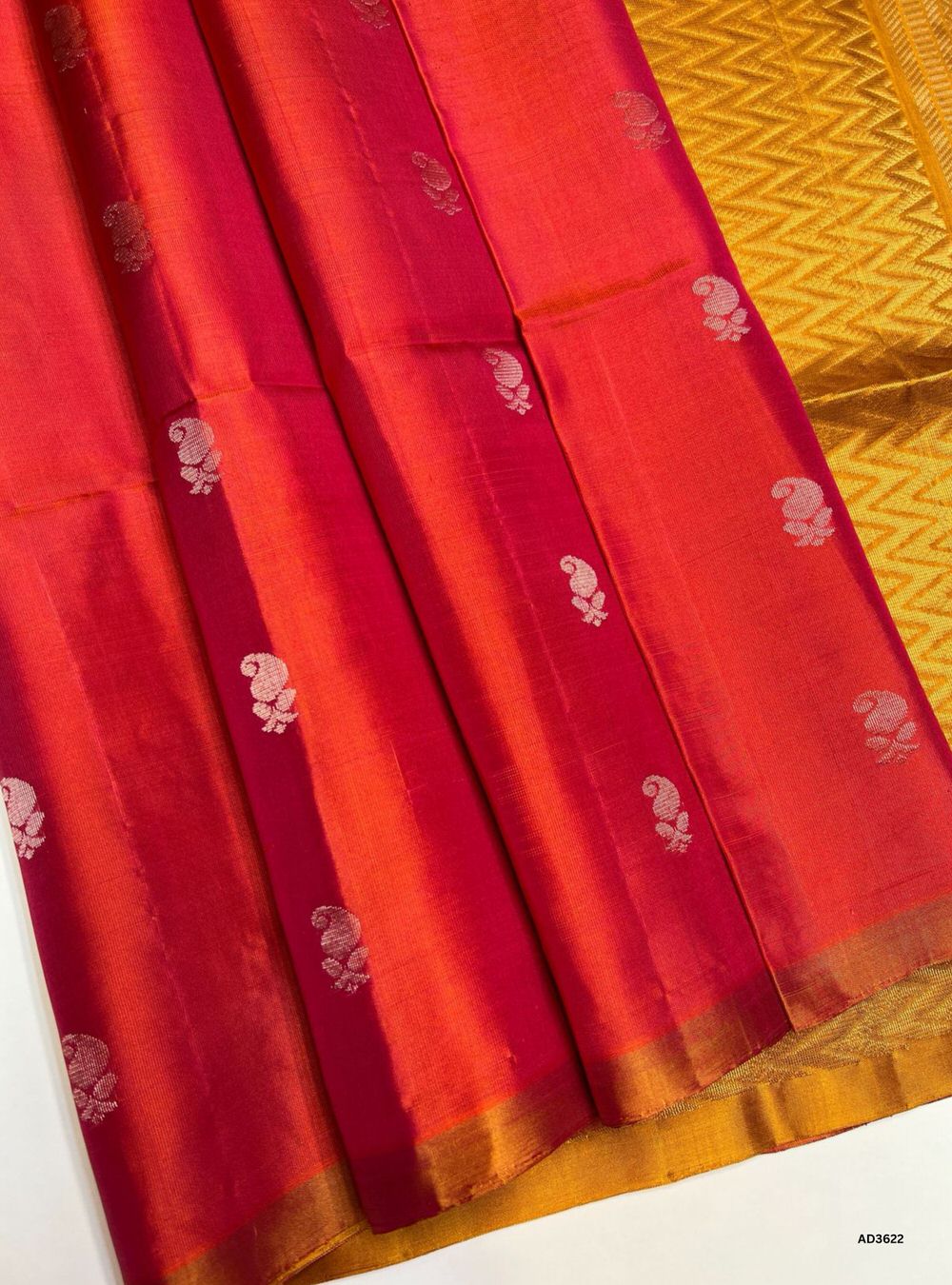 The Orangish Pink & Mustard Yellow Soft Silk Saree is a festive handwoven creation featuring a radiant orangish pink body enriched with shimmering zari. Its luminous mustard yellow border and pallu highlight the intricate bhutta weave motifs, adding elegance and traditional charm. Perfect for weddings, festive occasions, and cultural gatherings, this saree blends joyful vibrancy with timeless bhutta craftsmanship.