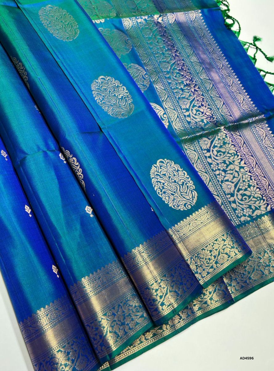 The Peacock Blue Kanchi Border Soft Silk Saree with Pure Gold Zari is a radiant handwoven creation that embodies festive brilliance and cultural richness, making it ideal for weddings, temple ceremonies, and auspicious occasions.