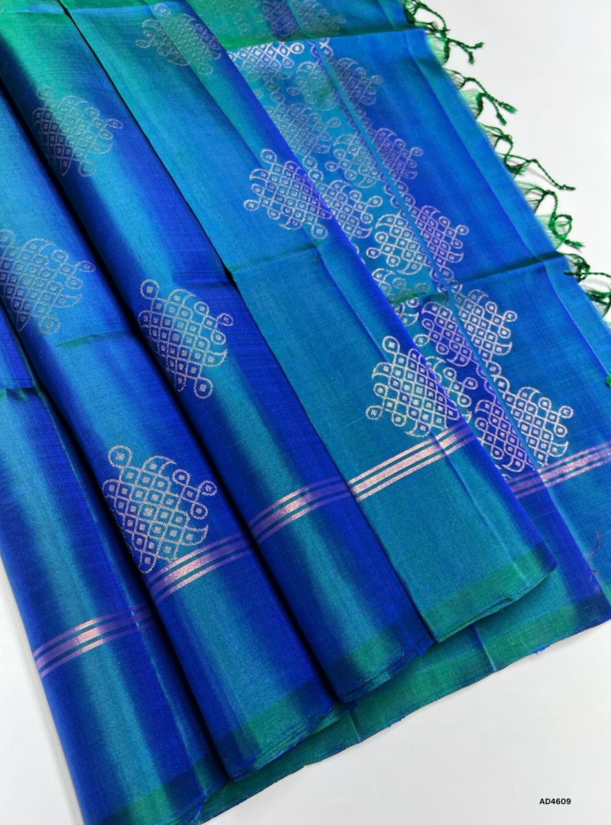The Peacock Blue Kolam Soft Silk Saree with Pure Gold Zari is a radiant handwoven creation that embodies festive brilliance and cultural richness, making it ideal for weddings, temple ceremonies, and auspicious occasions.