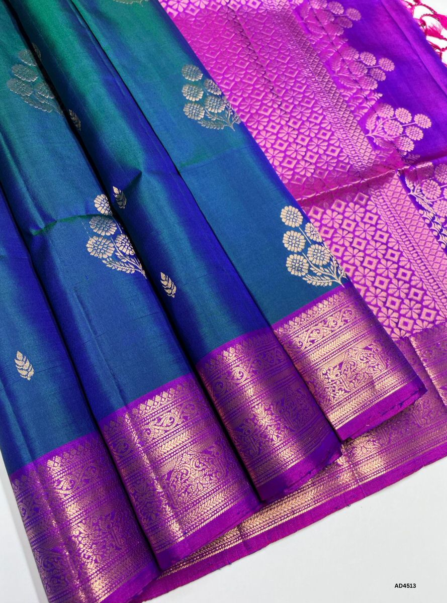 The Peacock Blue & Purple Kanchi Border Soft Silk Saree with Pure Gold Zari is a radiant handwoven creation that unites jewel‑tone vibrance with temple‑inspired elegance, making it ideal for weddings, festive occasions, and cultural ceremonies.