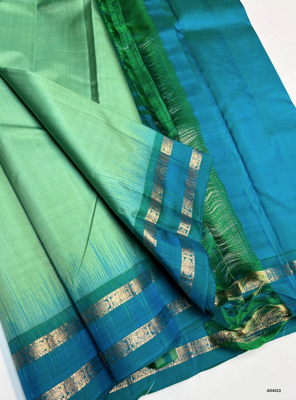 The Pepper Mint & Turquoise Plain Retta Pett Soft Silk Saree is a refreshing handwoven creation that radiates youthful charm and cultural elegance. The pepper mint shade conveys calmness, serenity, and modern refinement, while the turquoise adds vibrance, prosperity, and festive brilliance. The Retta Pett checkered weave enriches its traditional appeal, while the plain zari border and lustrous drape make it versatile for weddings, temple ceremonies, and festive occasions. A timeless piece of artistry, it bl