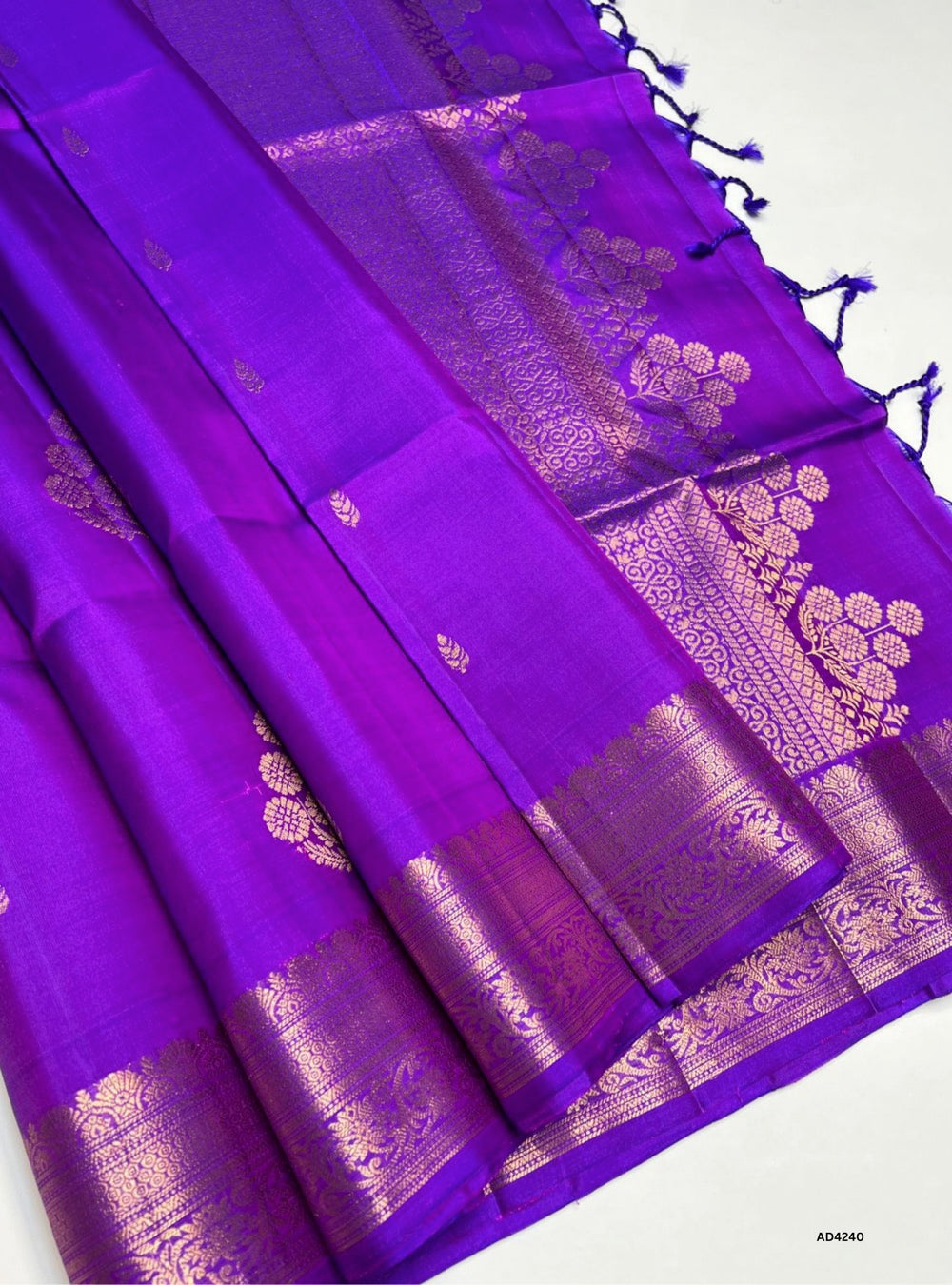 The Purple Kanchi Border Soft Silk Saree is a regal handwoven creation that radiates elegance and cultural richness. The purple shade symbolizes royalty, devotion, and spiritual depth, while the traditional Kanchi border enriched with pure gold zari elevates its heritage appeal. With its lustrous drape and coordinated blouse, this saree is perfect for weddings, temple ceremonies, and festive occasions. A timeless piece of artistry, it blends jewel‑tone vibrance with the grandeur of Kanchipuram weaving.