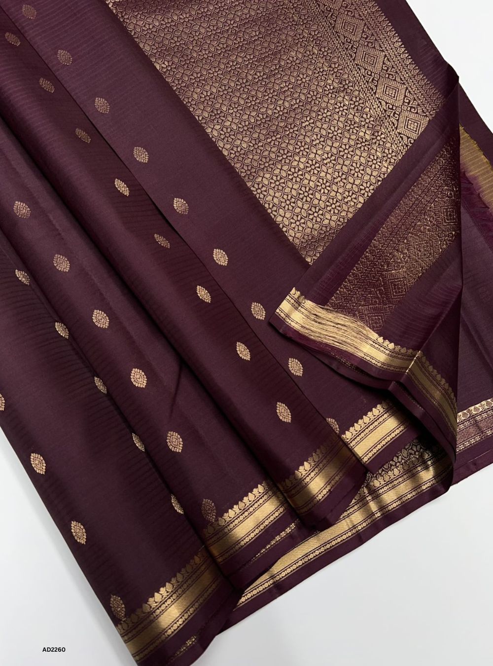 Purple saree with gold patterns on a white background