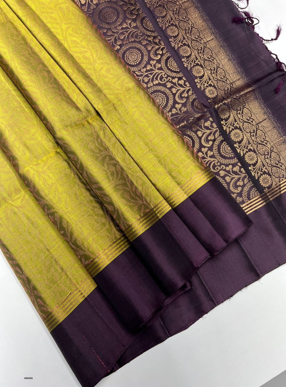 Saree with yellow and purple fabric and intricate border design.