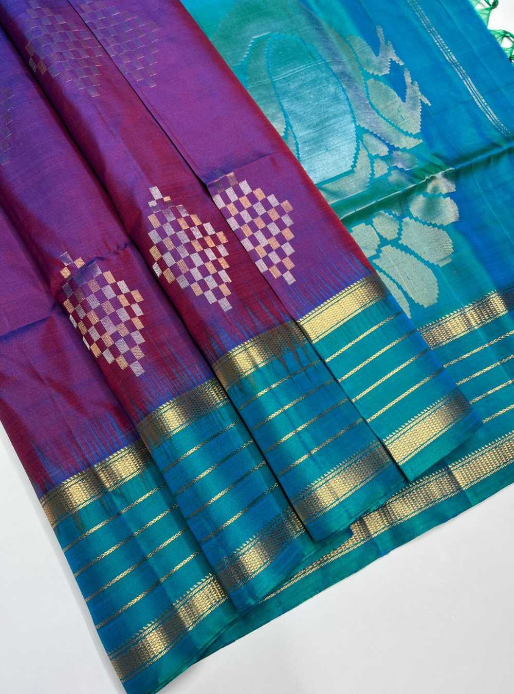 Two colorful sarees with intricate patterns on a white background