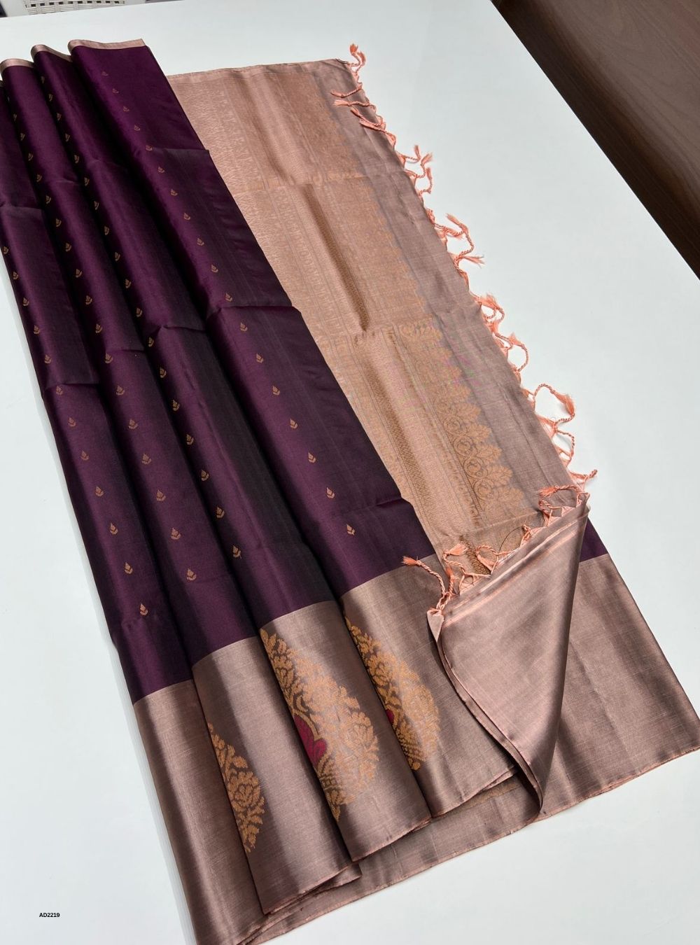 Two fabric swatches, one purple and one brown with decorative patterns, on a white surface.
