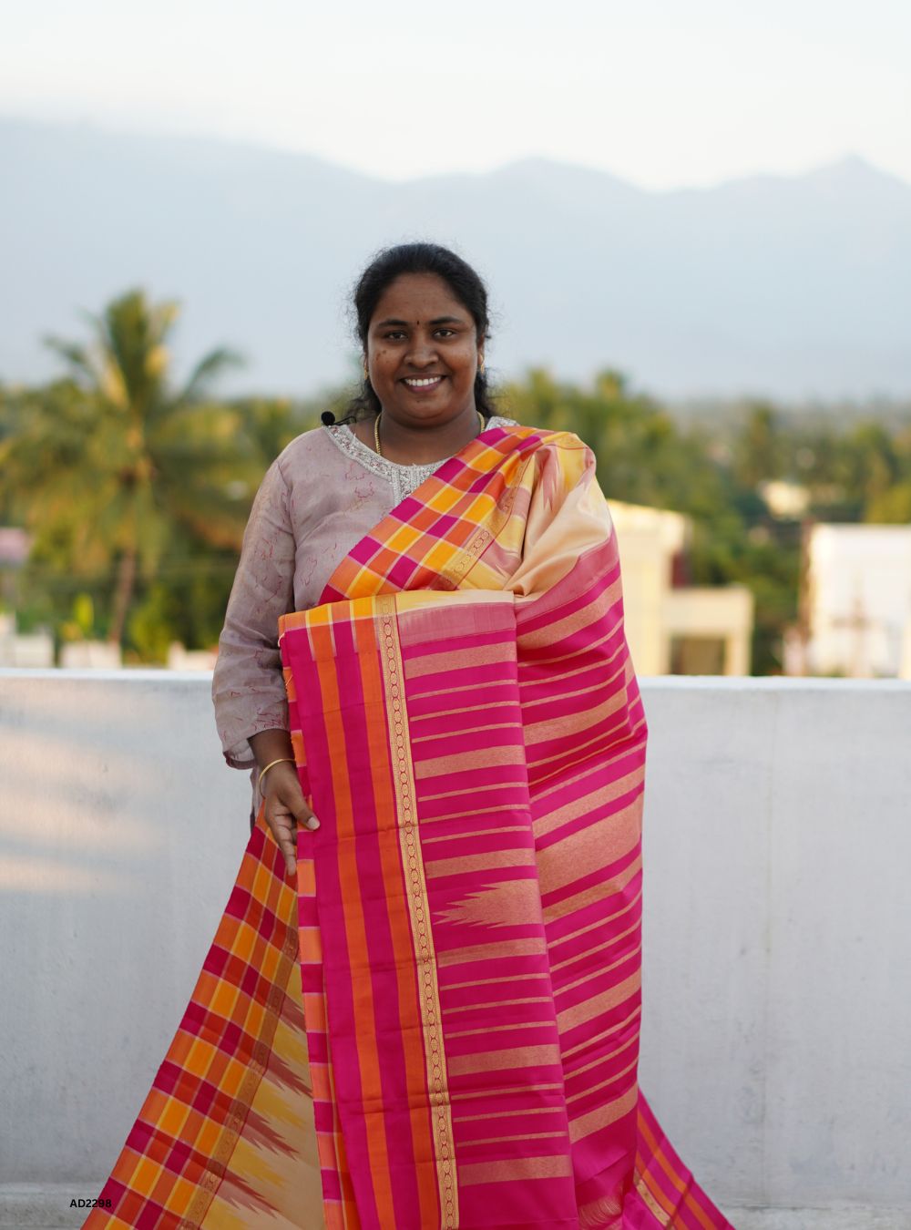 Woman wearing a colorful saree with a scenic background