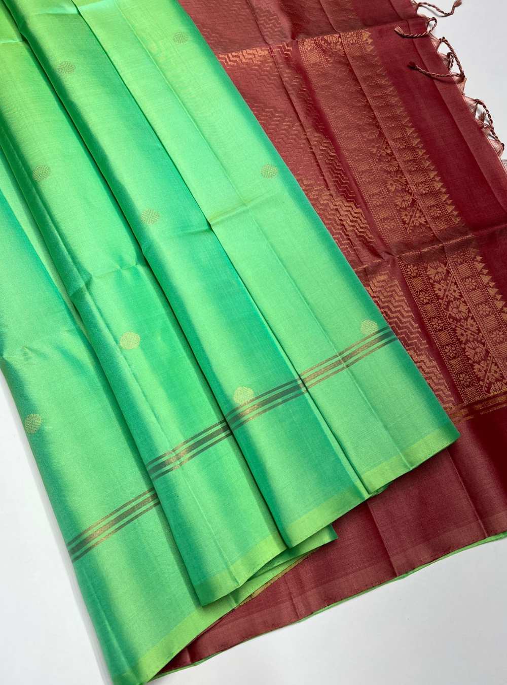 Rexona Green and Dusty Peach Soft Silk Saree with bhutta motifs and gold zari border, festive wear.