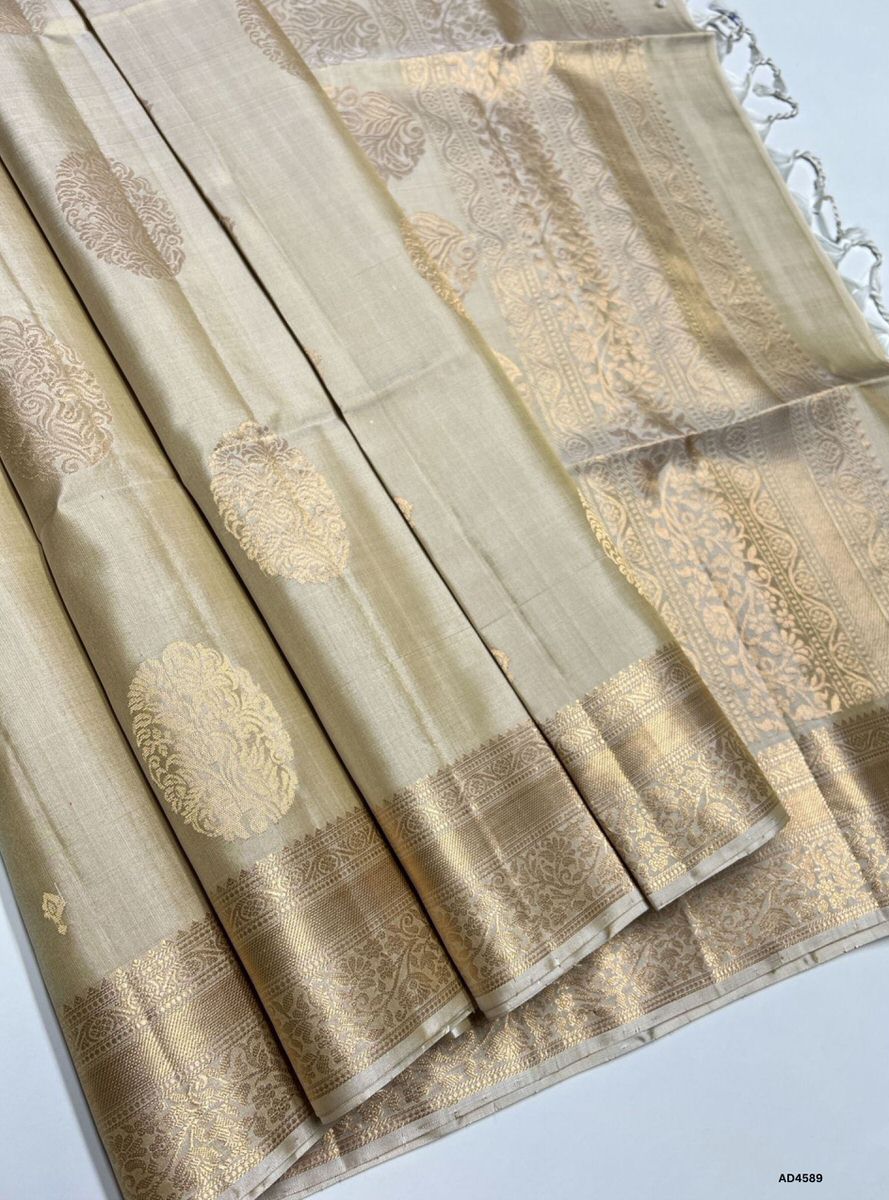 The Beige Kanchi Border Soft Silk Saree with Pure Gold Zari is a graceful handwoven creation that radiates understated charm and cultural richness, making it perfect for weddings, temple ceremonies, and festive occasions.