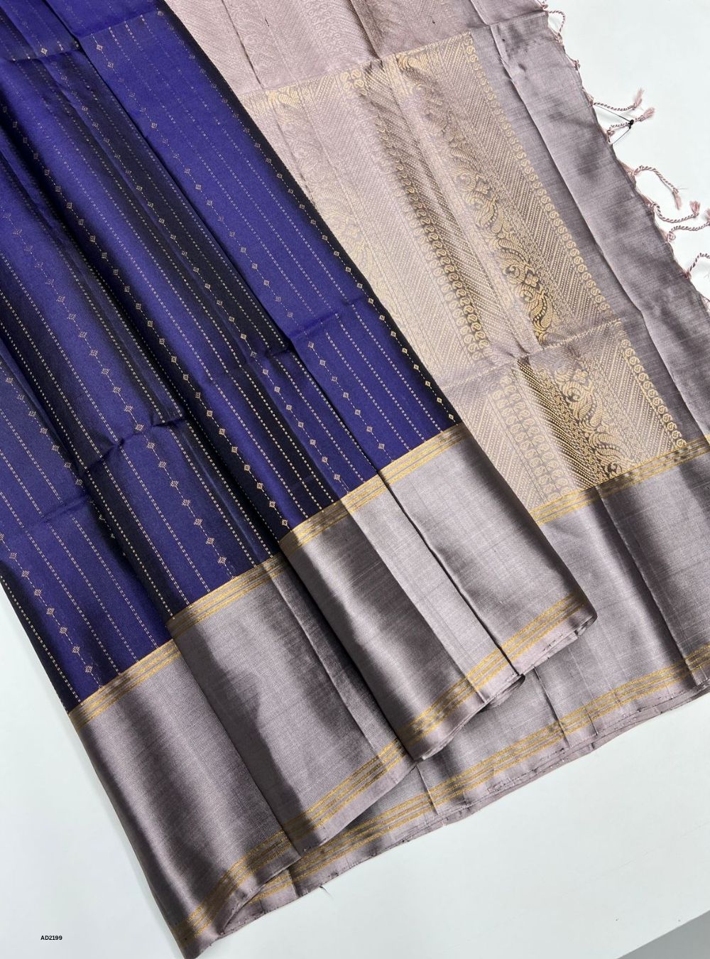 Blue and gray saree with gold border on a white background
