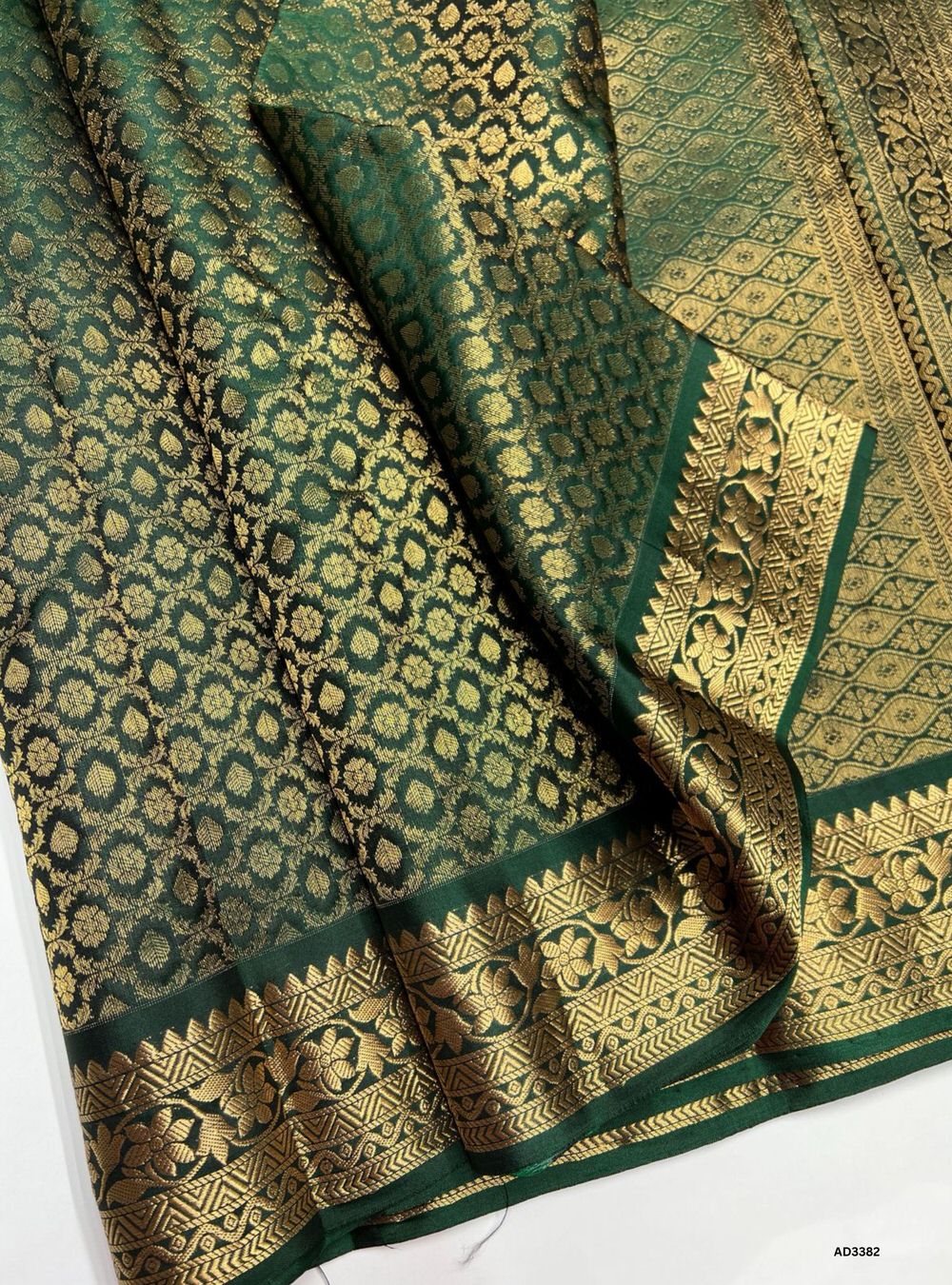 "Handwoven Bottle Green body Empose Jacquard Border Soft Silk Saree featuring gold zari motifs and borders"