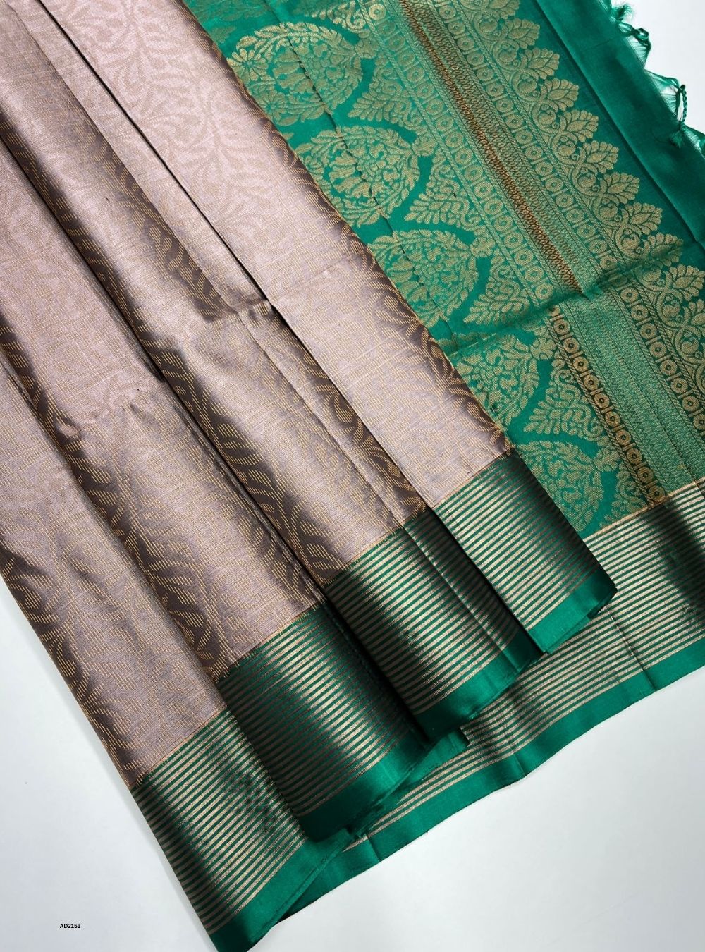 Brown and green saree with intricate patterns on a white background