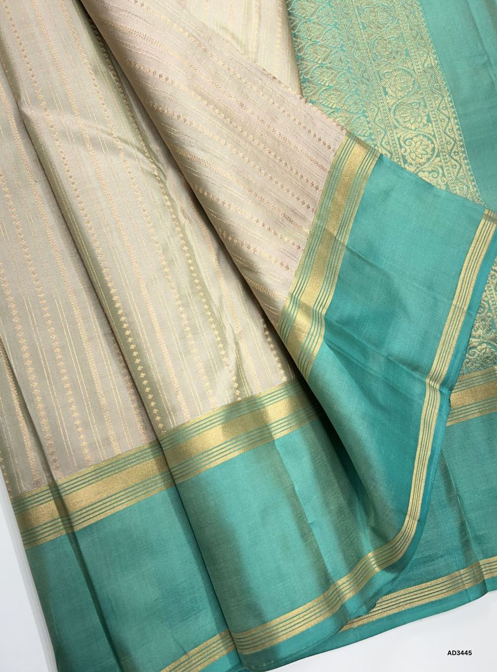 "Handwoven Champagne body with Blue contrast border Striped Bhutta Soft Silk Saree featuring gold zari motifs"