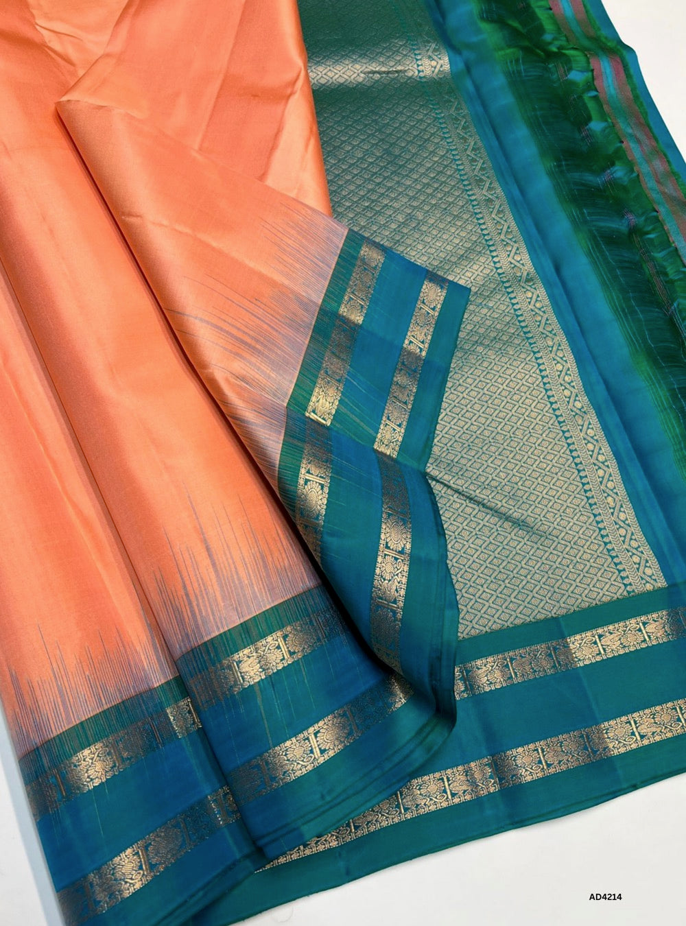 The Coral & Turquoise Plain Retta Pett Soft Silk Saree is a lively handwoven creation that radiates festive charm and cultural elegance. The coral shade conveys joy, warmth, and celebration, while the turquoise adds freshness, prosperity, and modern sophistication. The Retta Pett checkered weave enriches its traditional appeal, while the plain zari border and lustrous drape make it versatile for weddings, temple ceremonies, and festive occasions. A timeless piece of artistry, it blends heritage checks with 