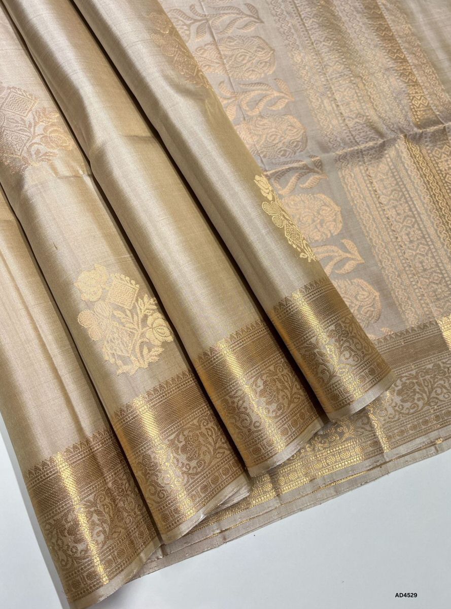 The Cream Kanchi Border Soft Silk Saree with Pure Gold Zari is a timeless handwoven creation that radiates understated elegance and cultural richness, making it ideal for weddings, temple ceremonies, and festive occasions.